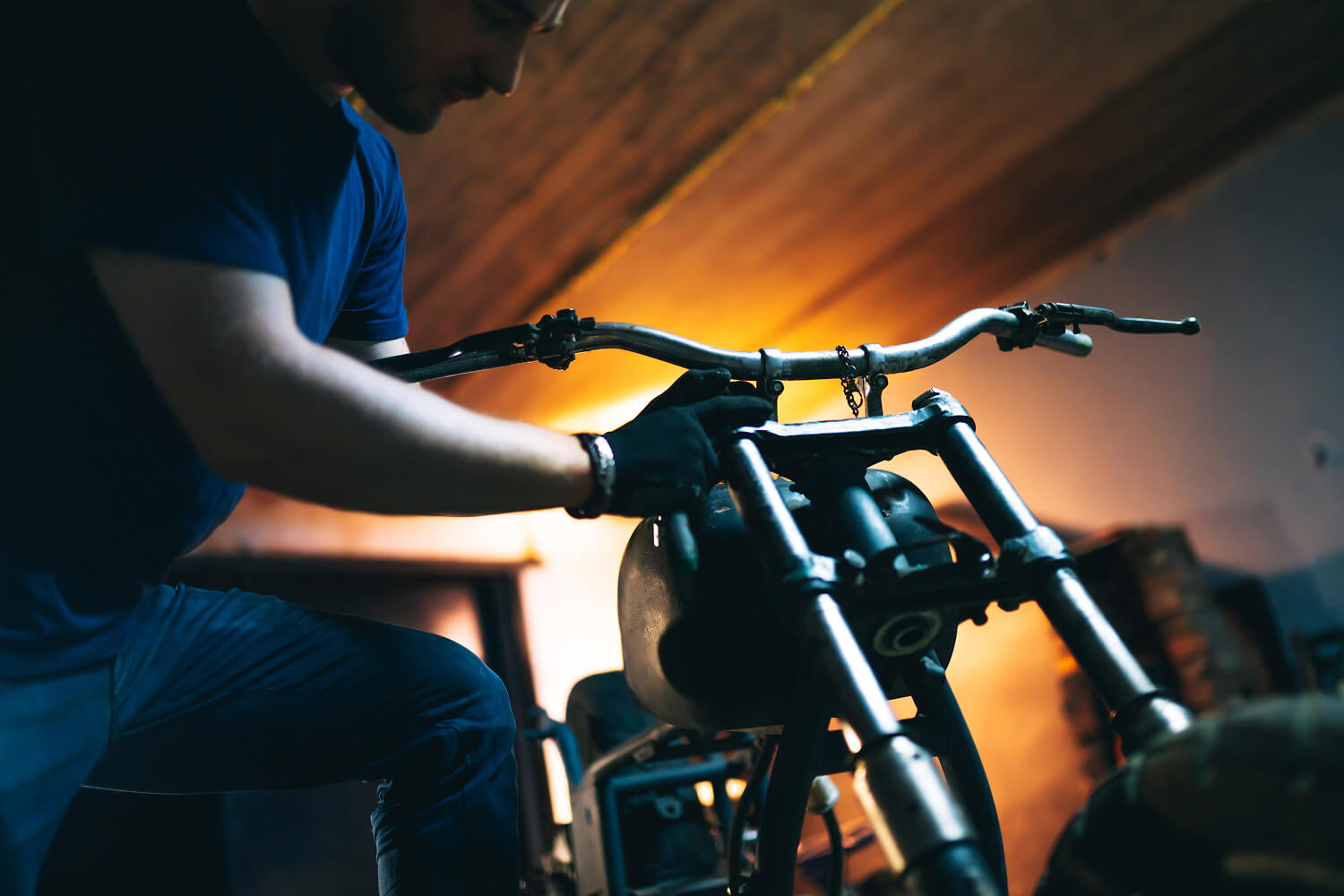 Mechanic repairing a disassembled motorcycle.