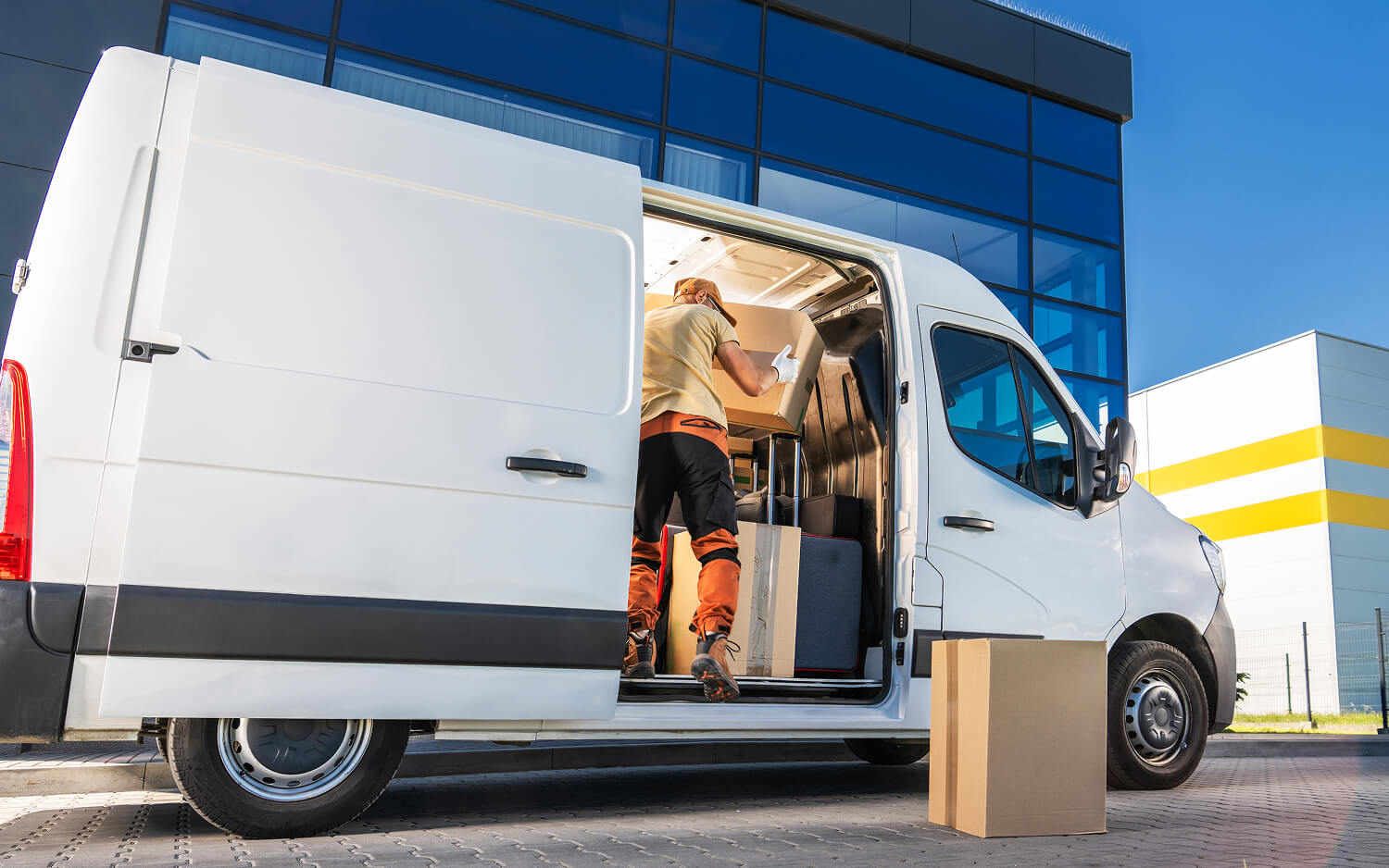 Delivery worker loading boxes into a delivery van.