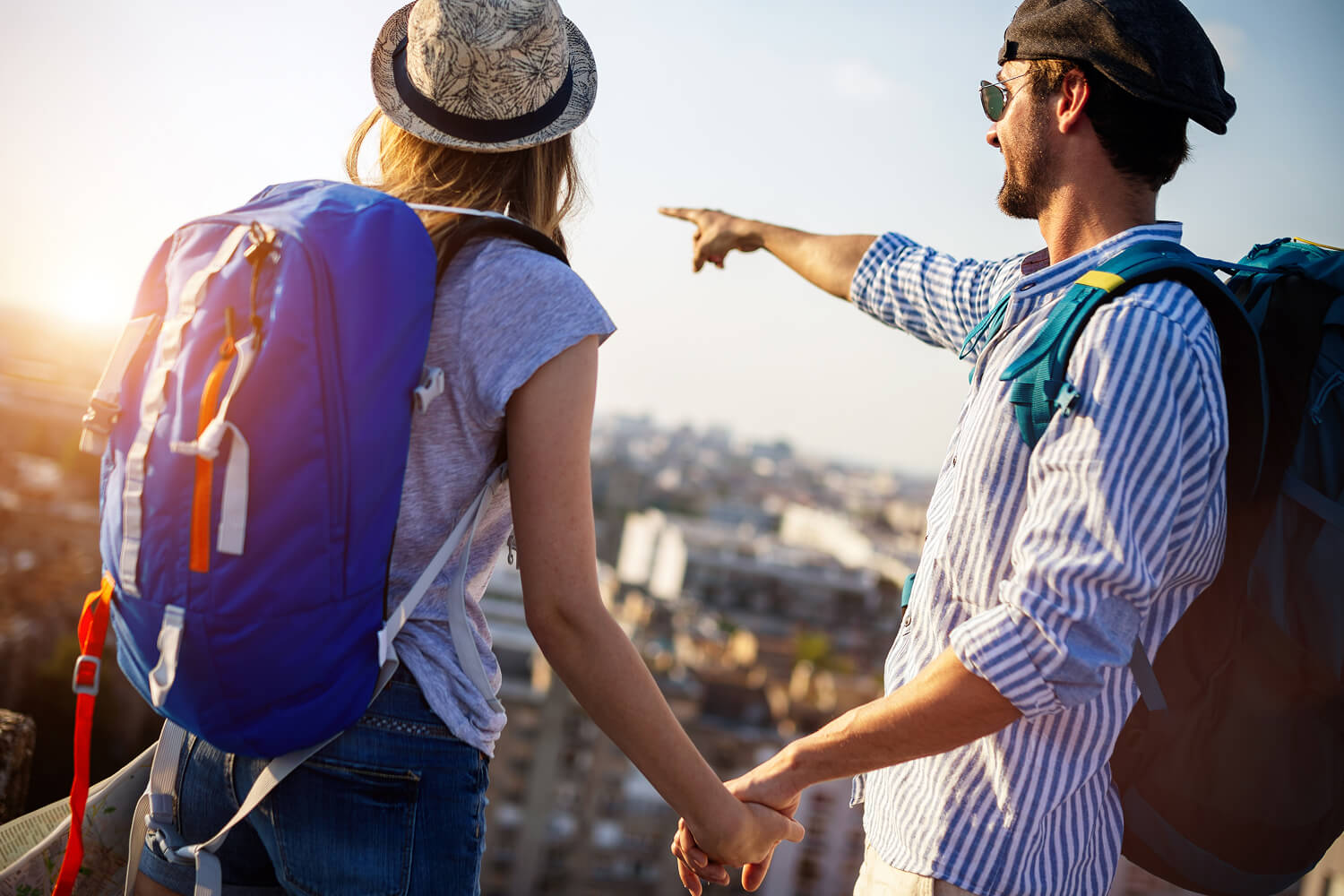 Couple exploring a city skyline with backpacks.