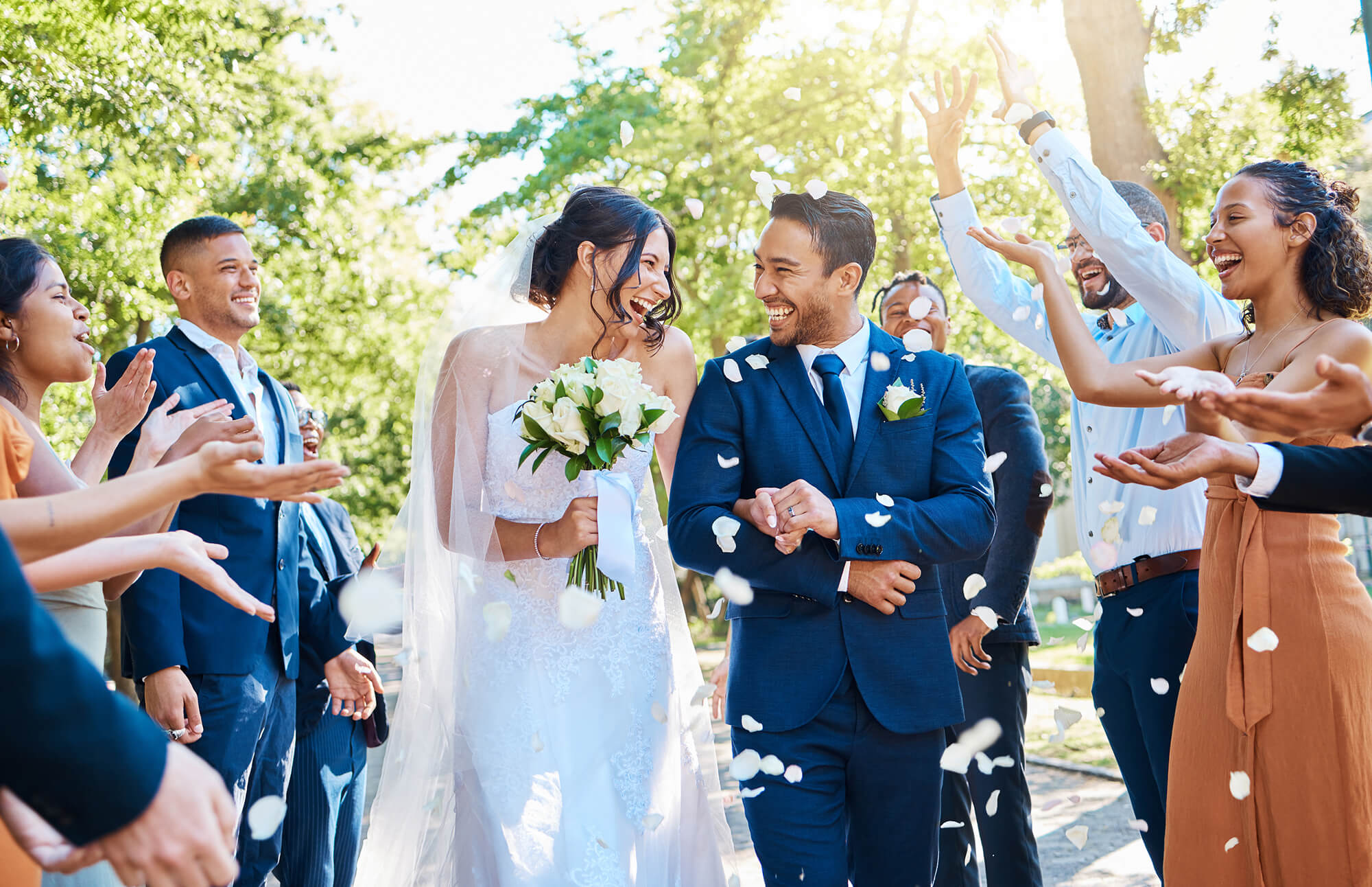 Newlyweds celebrating with guests as flower petals are tossed.