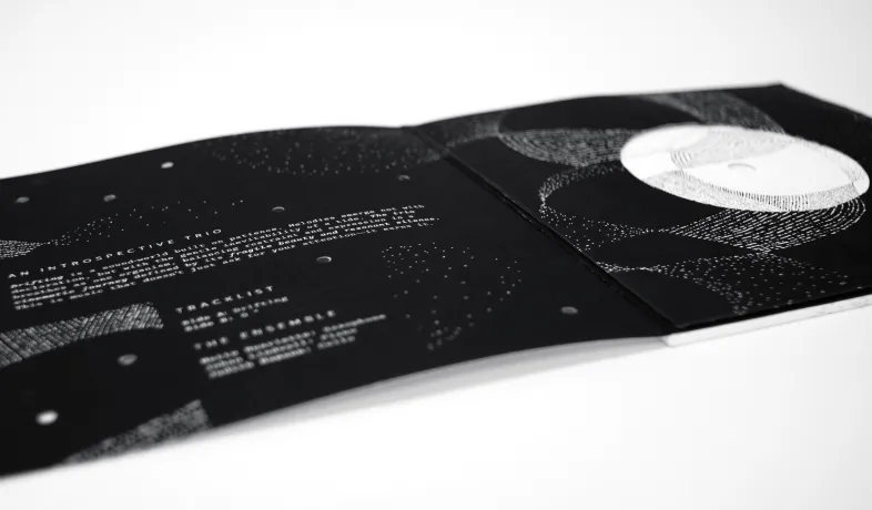 Open black CD case with white abstract line art and text tracklist on left side.
