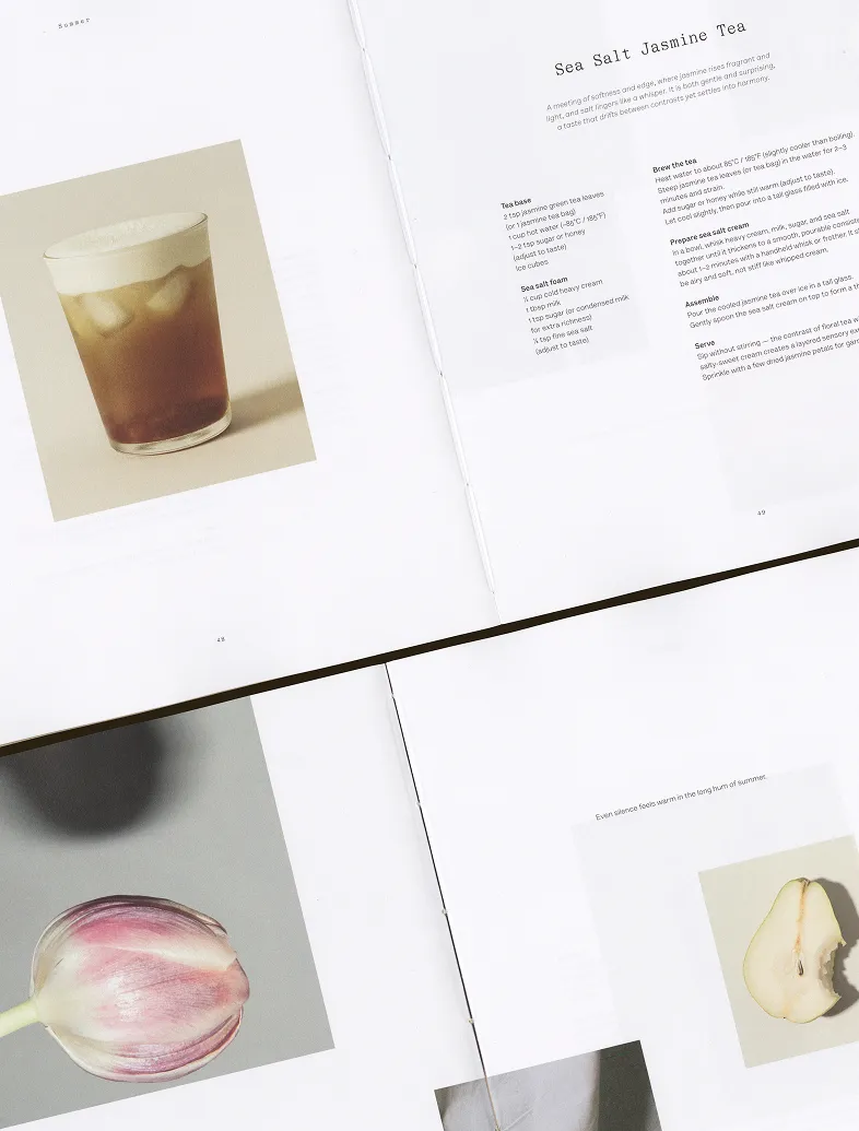 Open book showing a Sea Salt Jasmine Tea recipe and photos of a drink, a tulip, and a sliced pear.