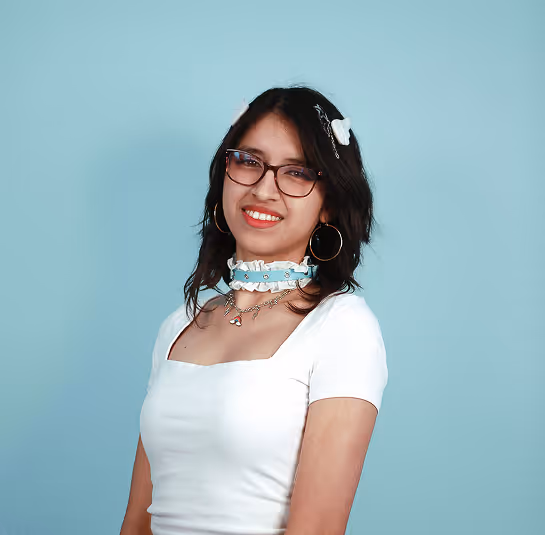 Young woman with glasses, white top, blue choker, and butterfly hair clips on light blue background.