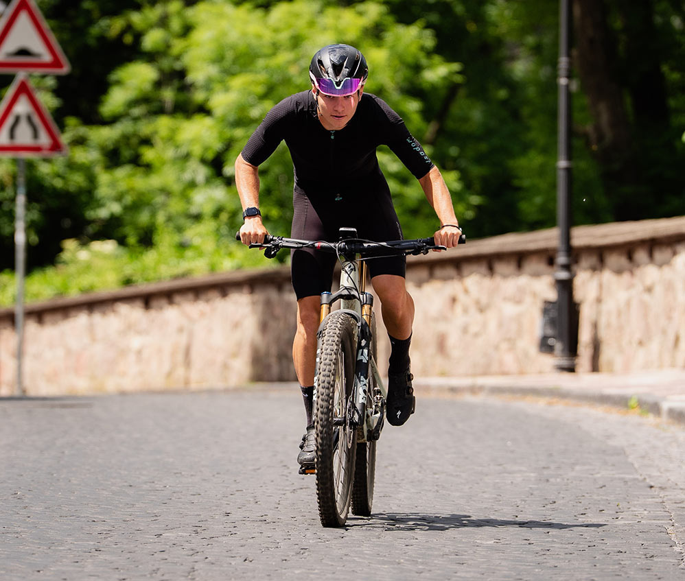 Cyklista na horskom bicykli na dláždenej ceste