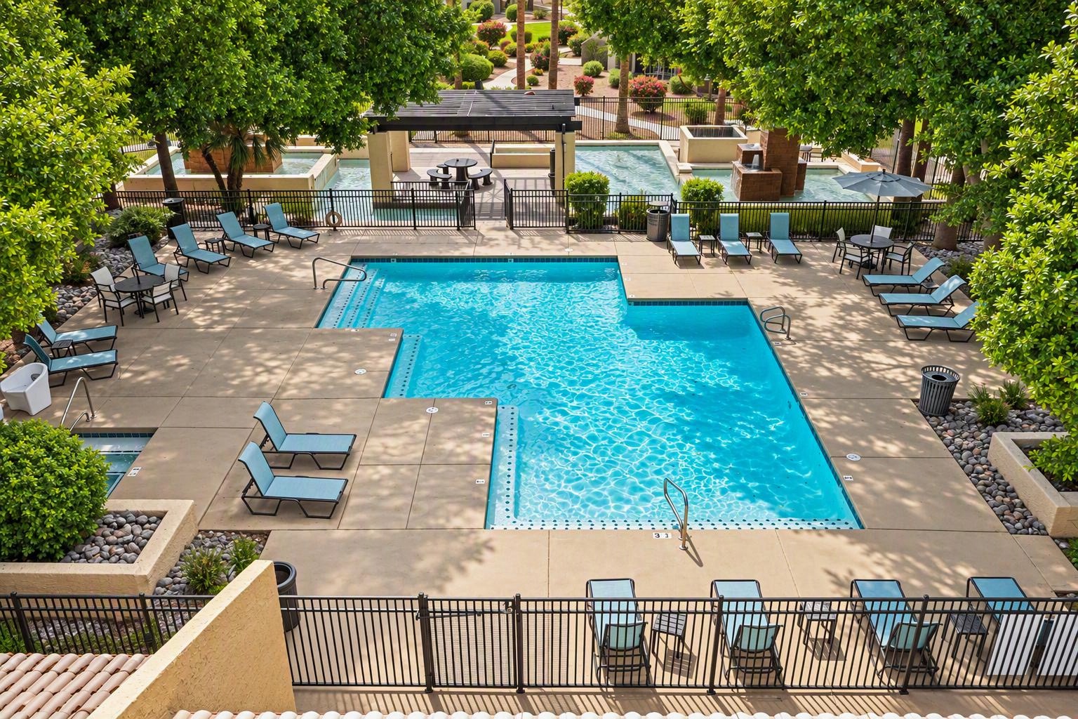 Gated swimming pool with lounge chairs