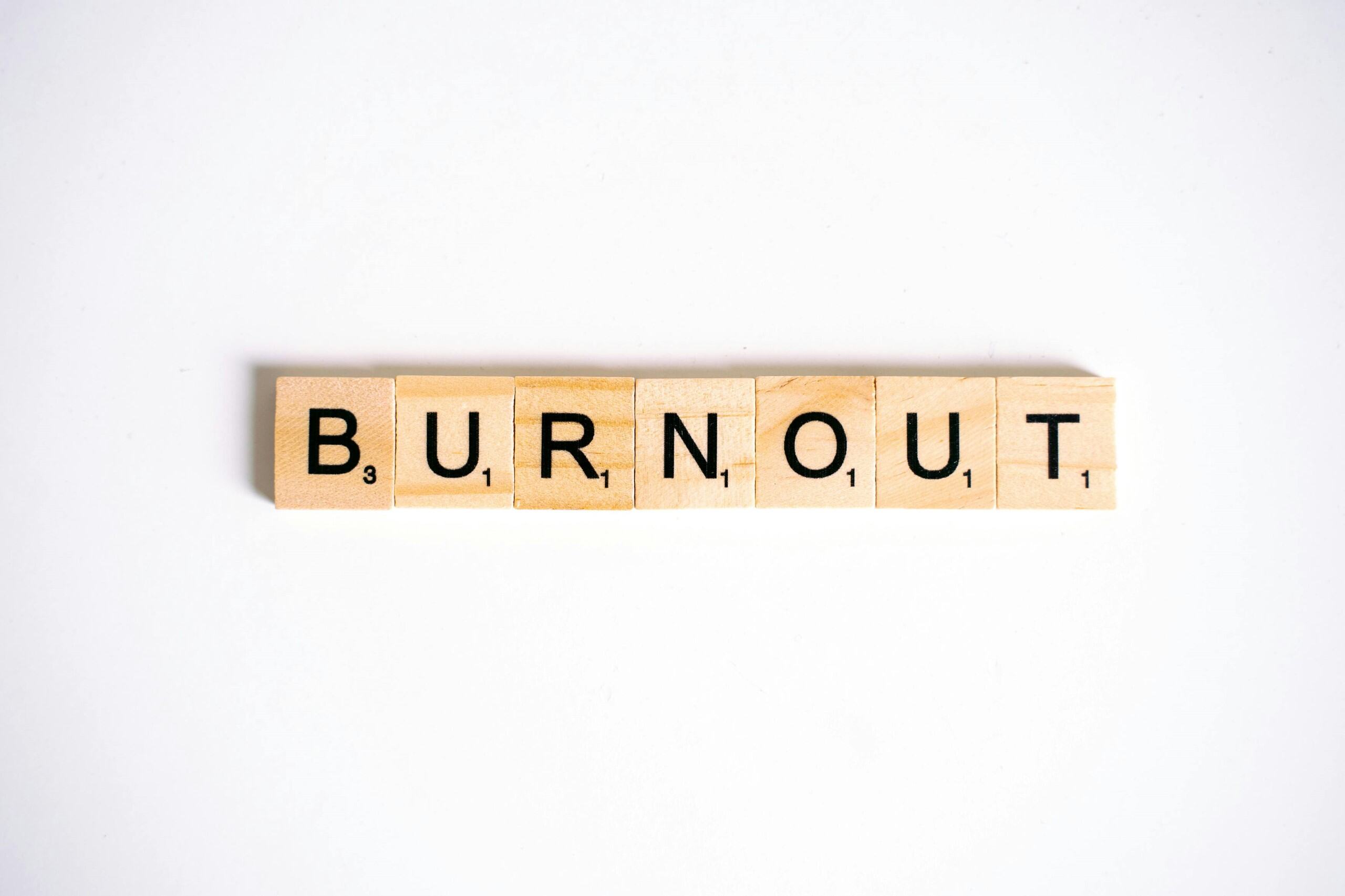 Scrabble tiles spelling "BURNOUT" arranged in a row on a white background.