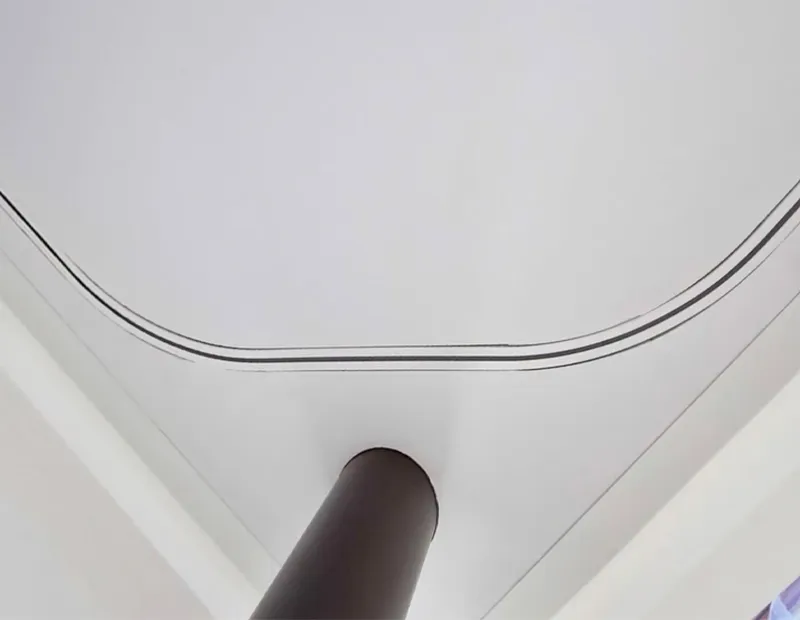 Ceiling with curved molding and a dark cylindrical pillar extending upward.