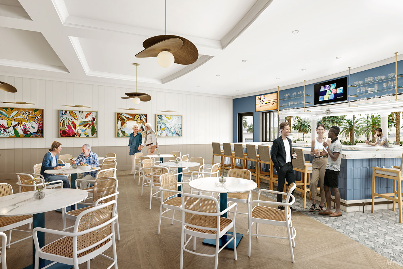 Bright, modern indoor lounge and bar area with white and tan furniture, wooden floor, artistic paintings on the walls, ceiling fans with round lights, and groups of people socializing at tables and the bar with palm trees visible outside large windows.