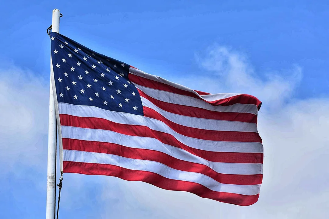 An American flag waving in the wind on a background of a blue sky