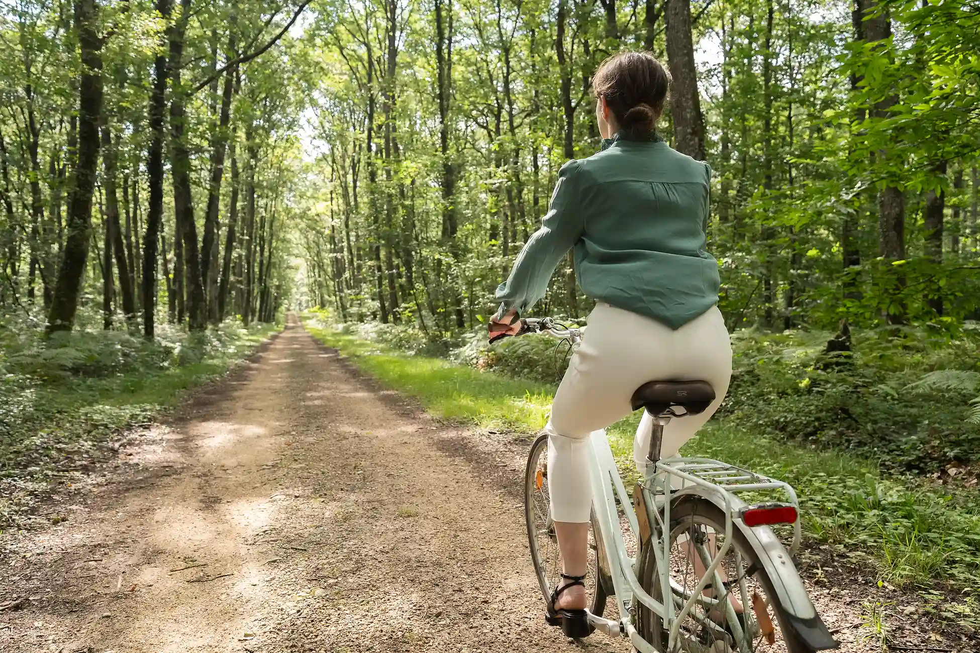 Eine Person fährt auf einem Waldweg in den Hauts de Loire Fahrrad.