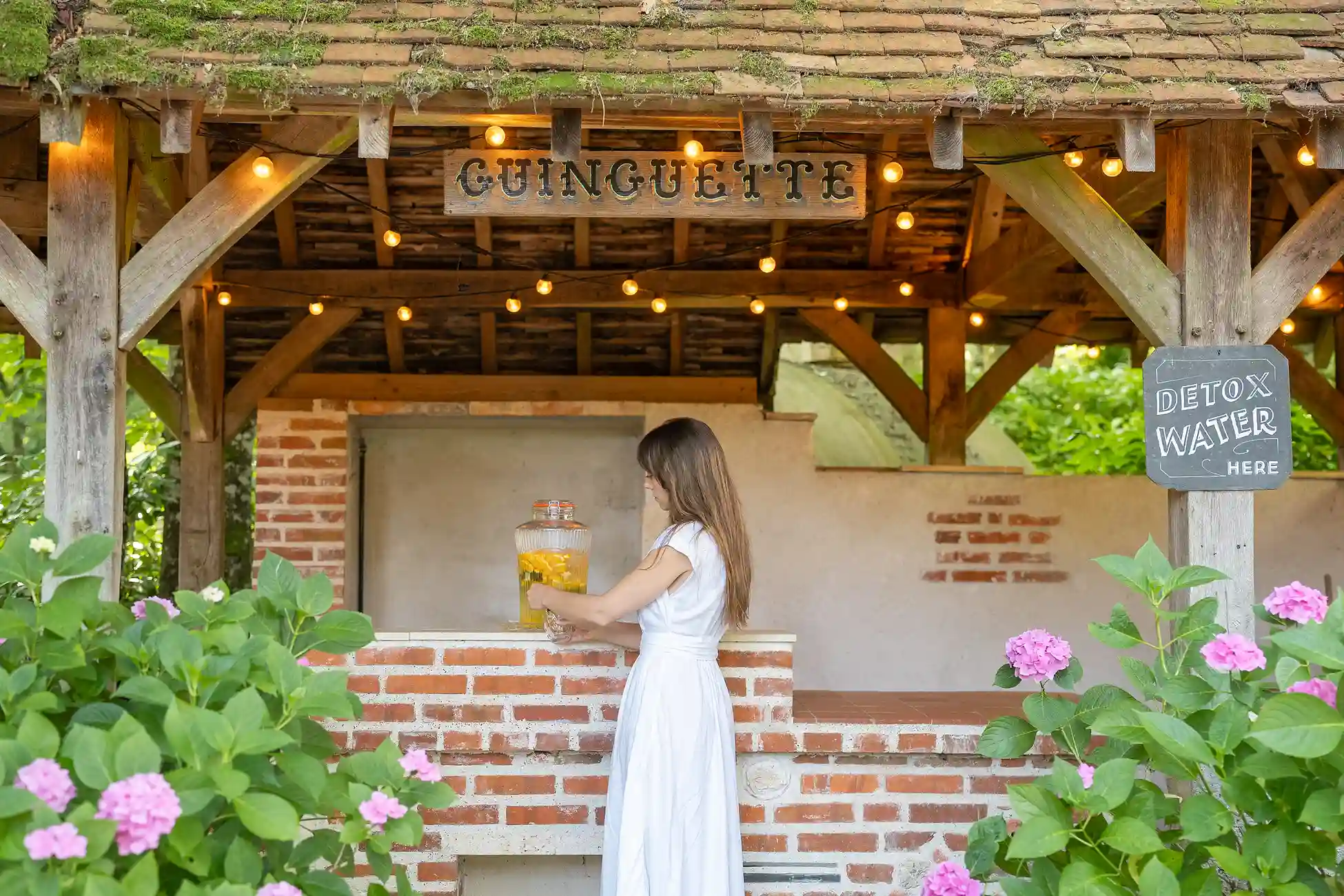 Frau in einem weißen Kleid nahe einem Außenbereich im Les Hauts de Loire – Hotel, Restaurant & Spa.