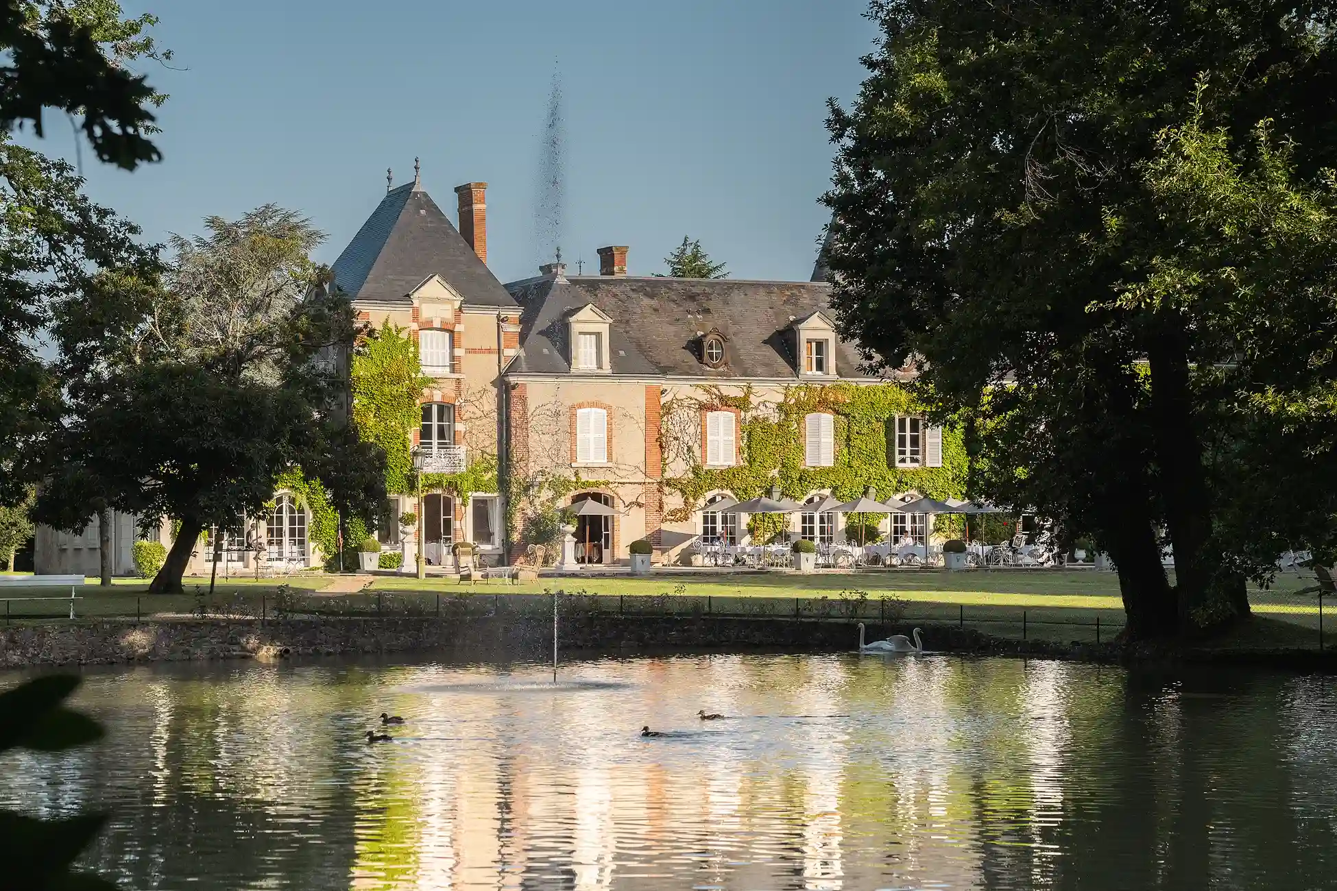 Blick auf das Château Les Hauts de Loire, das sich im Teich spiegelt.