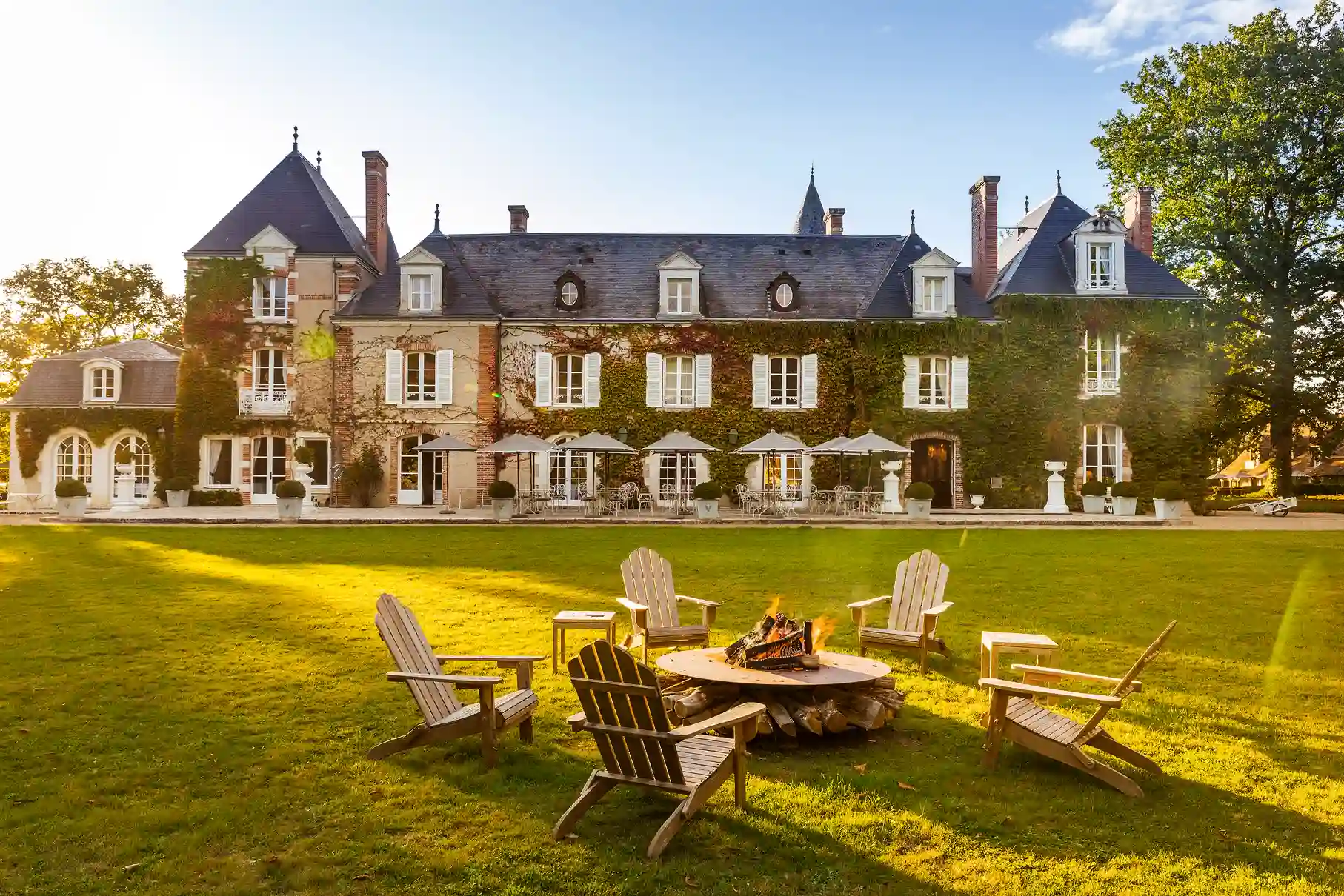 Fassade des Château Les Hauts de Loire und Sitzbereich im Freien auf der Rasenfläche.
