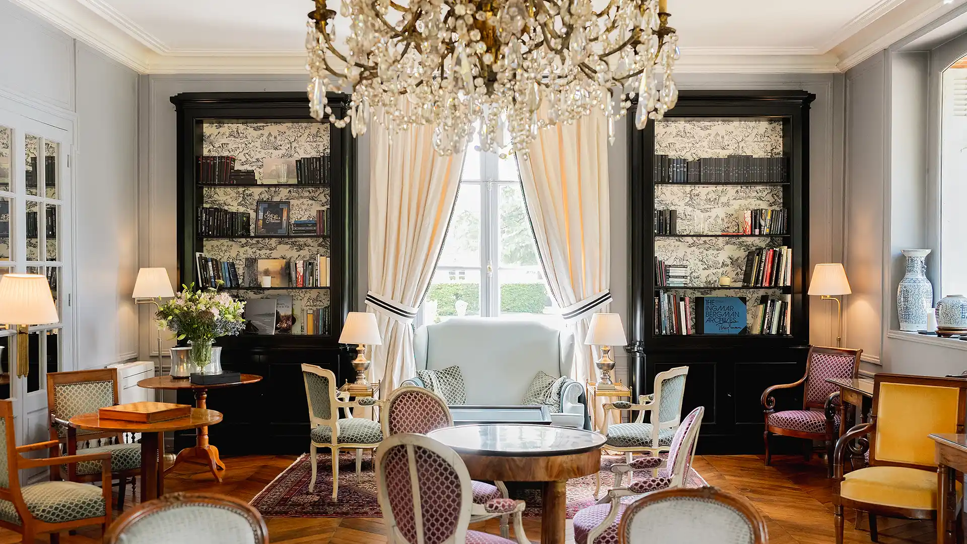 Une vue plus large du salon du château avec des fauteuils d'appoint jaunes et un canapé, faisant partie de "Les Hauts de Loire – Hôtel, Restaurant & Spa – 5 étoiles".