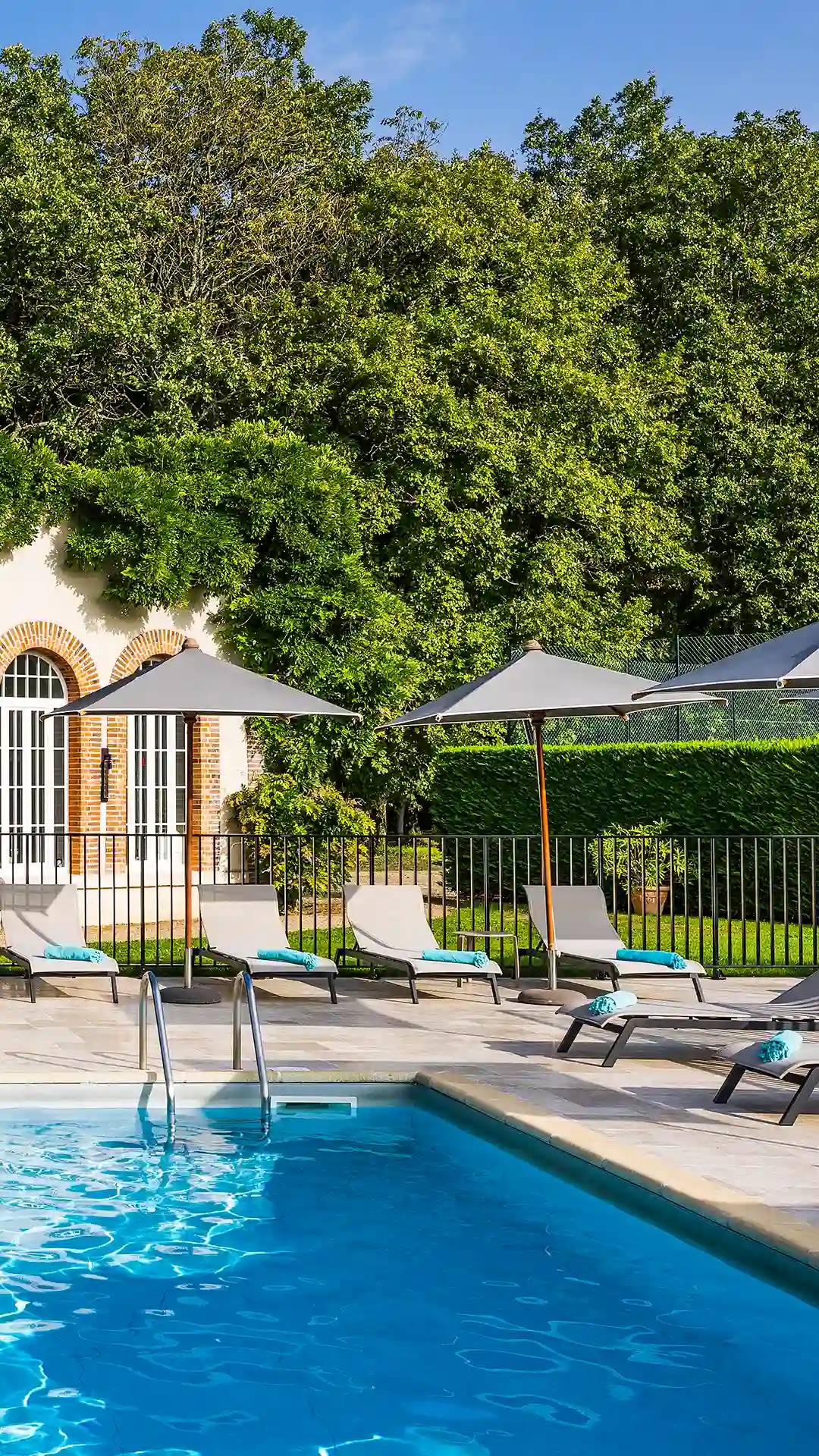 Der funkelnde Swimmingpool des 5-Sterne-Hotels Les Hauts de Loire – Hotel, Restaurant und Spa – mit üppigem Grün im Hintergrund.