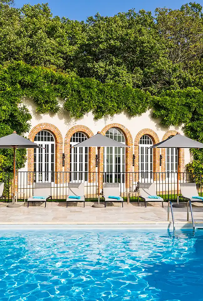 Close-up of the arches on the façade and the sun loungers by the pool at the 5-star Hotel Les Hauts de Loire – Hotel, Restaurant & Spa.
