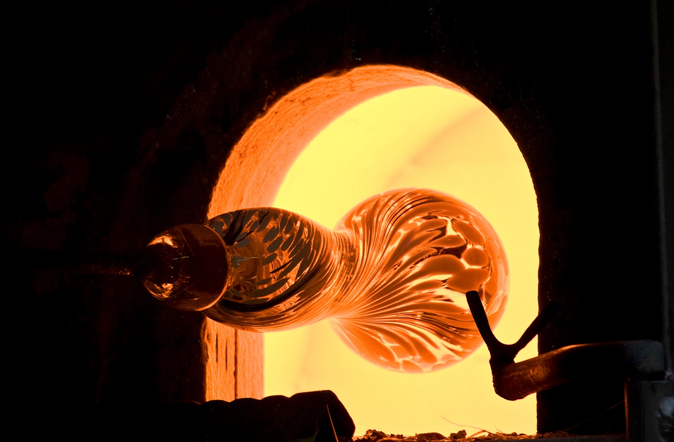 La structure texturée et détaillée du verre en fusion est éclairée par la chaleur intense du four.