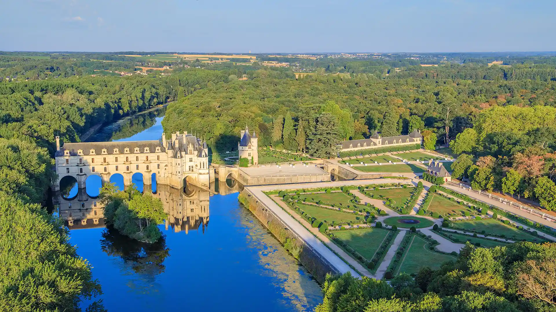 Perspective en plongée du château de Chenonceau et de ses jardins géométriques. L'élégance absolue aux Hauts de Loire – Hôtel, Restaurant & Spa – 5 étoiles.