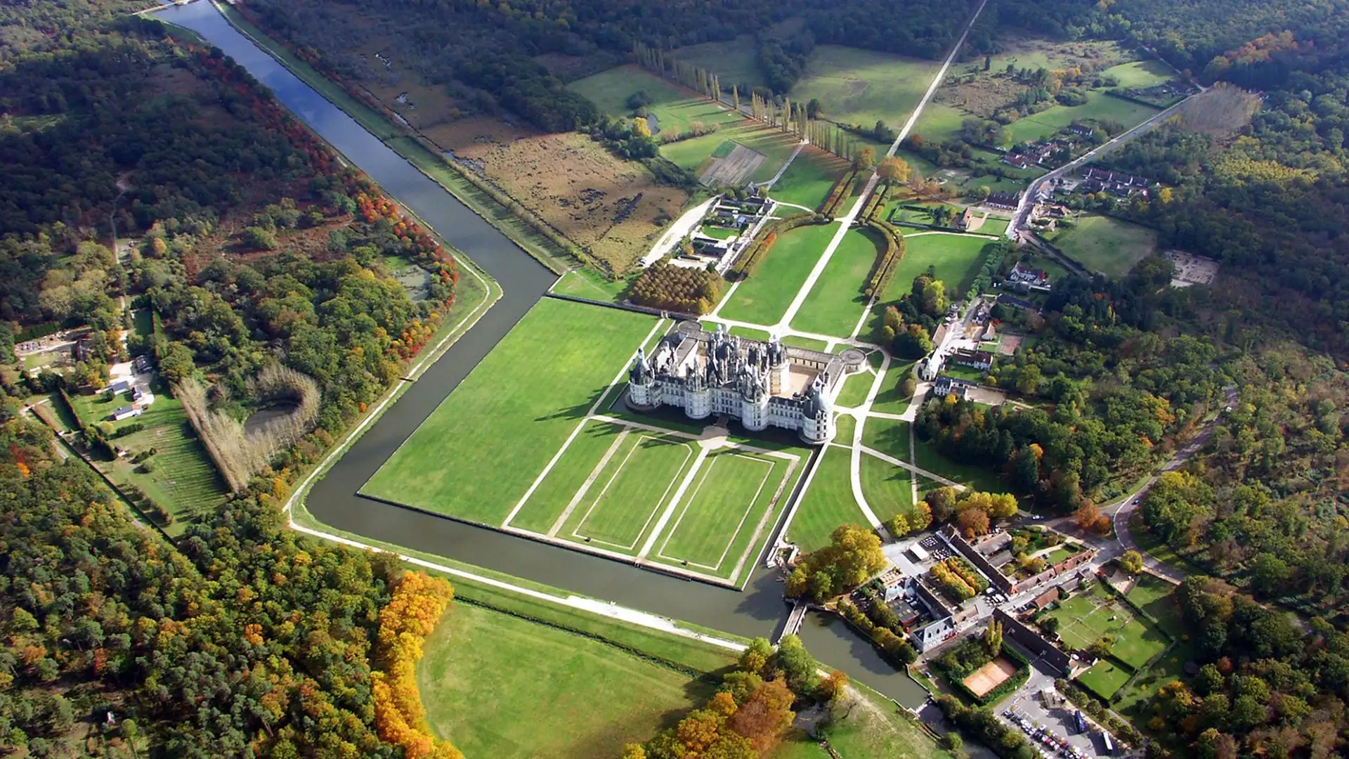 Fotografía tomada con dron del castillo en forma de L y sus jardines: un sello distintivo de 5 estrellas.