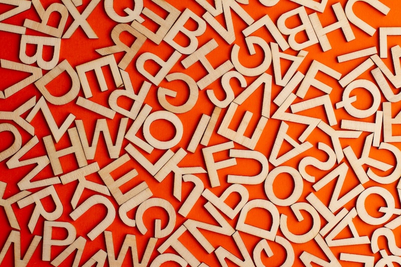 wooden letters scattered on orange background fonts typeface licensing