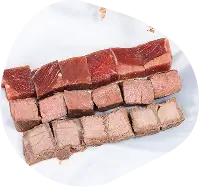 Rows of raw meat cuts and cubes from three different proteins