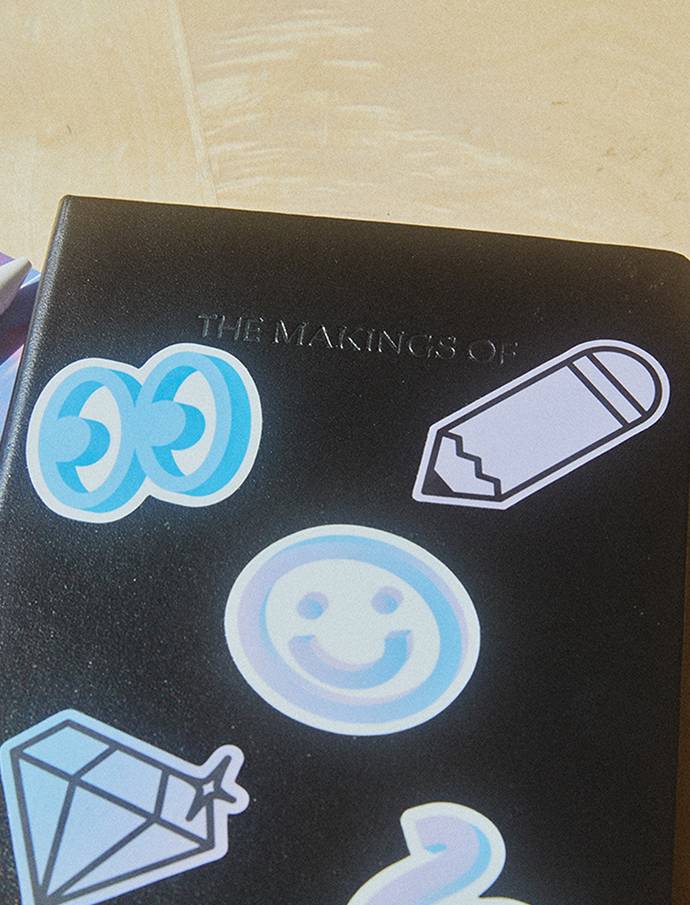 Close-up of Google custom black notebook with illustrated stickers