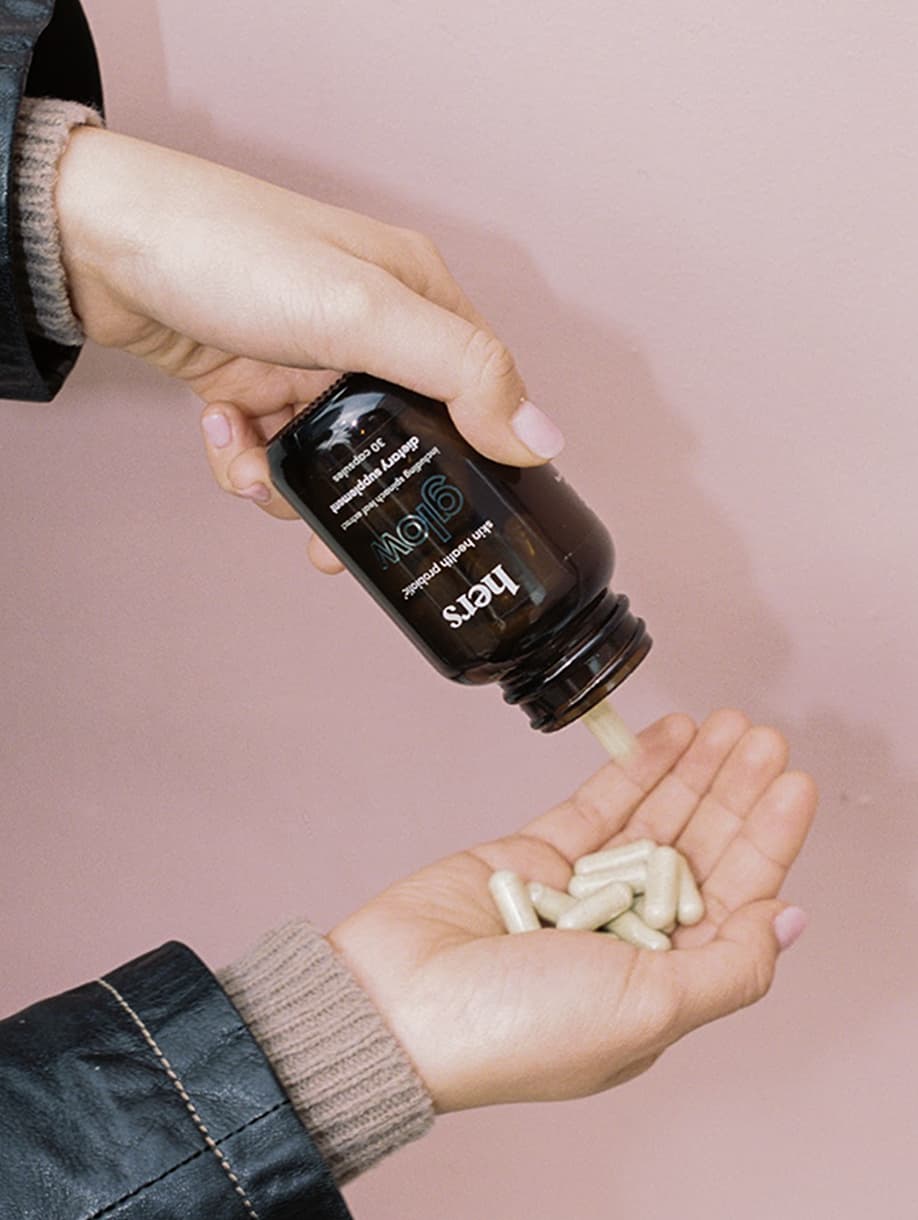 Hers wellness supplements poured into hand