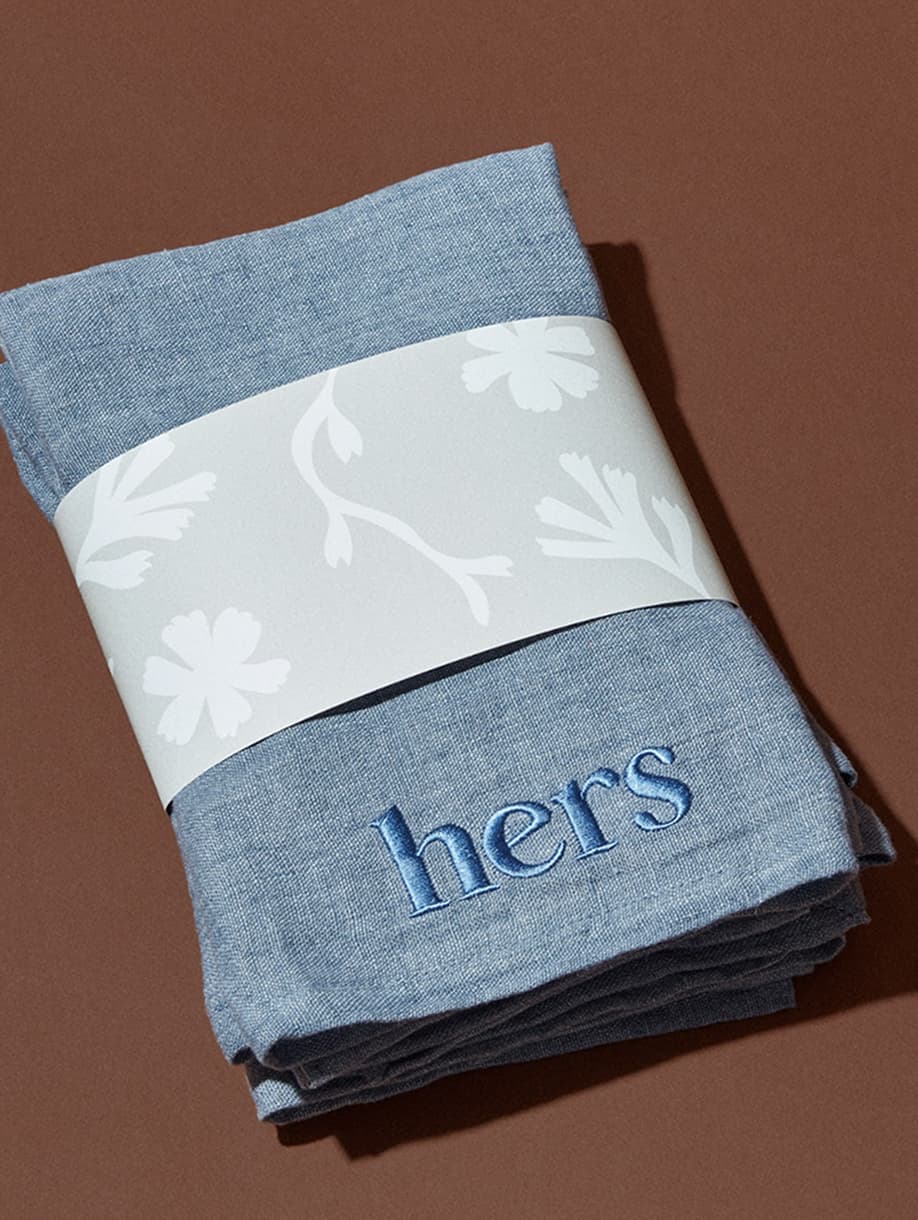 Hers custom blue linen napkins with embroidered logo and floral wrap