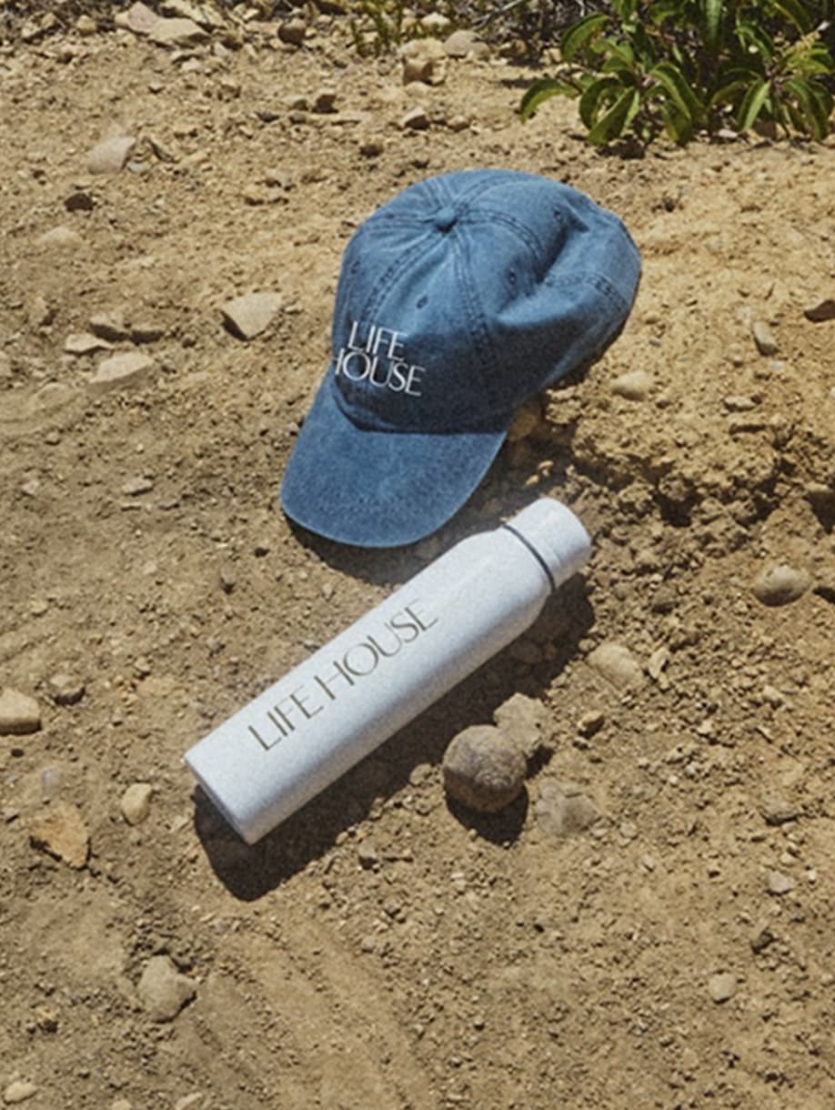 Life House custom blue baseball cap and white water bottle outdoors