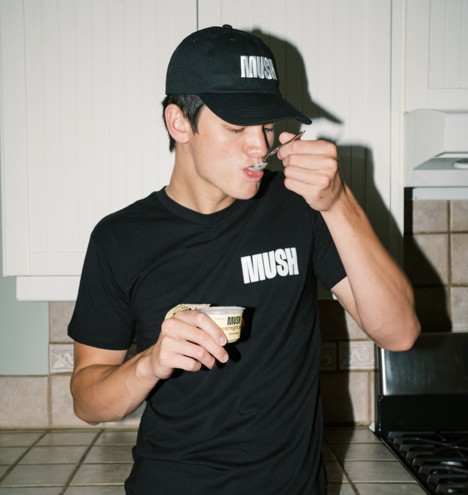 MUSH branded employee swag featuring a black T-shirt and cap