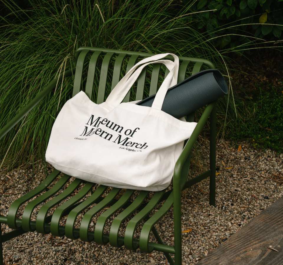 Custom Museum of Modern Merch white toe with yoga mat on green outdoor chair