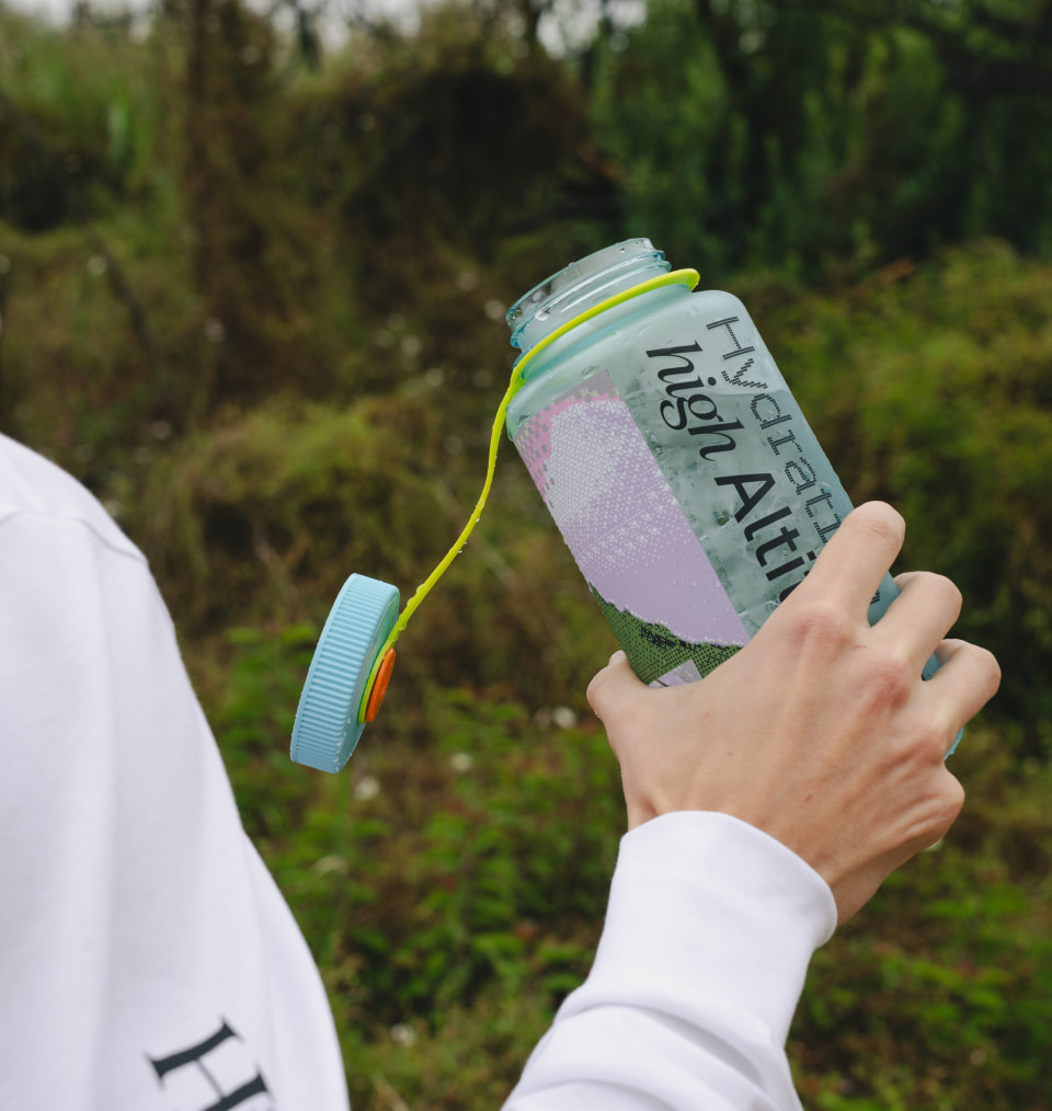 Model holding Altitude branded water bottle outside