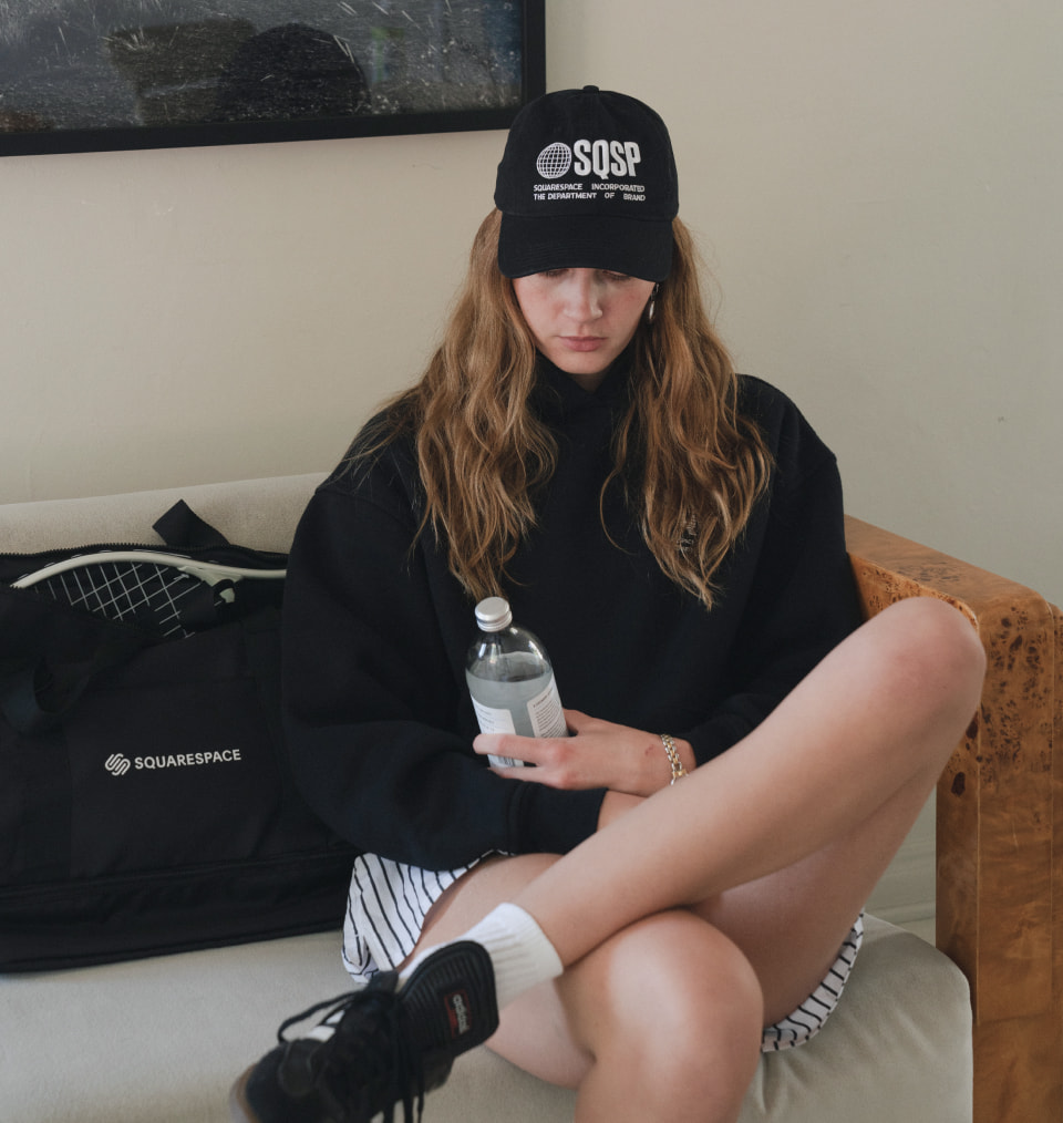 Squarespace branded hat on model next to a branded bag