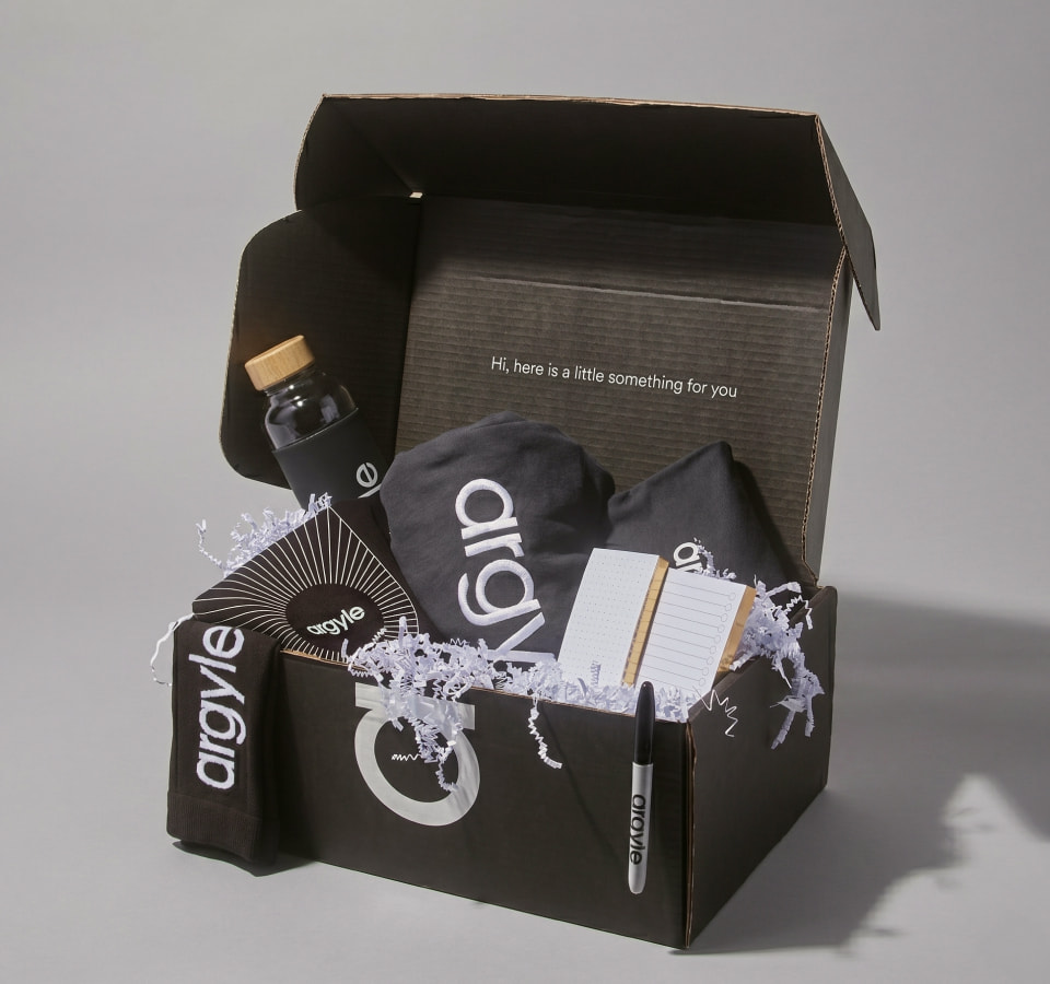 Argyle new hire kit featuring sharpie, tee, notebook, water bottle, tote inside black and white custom box. with
