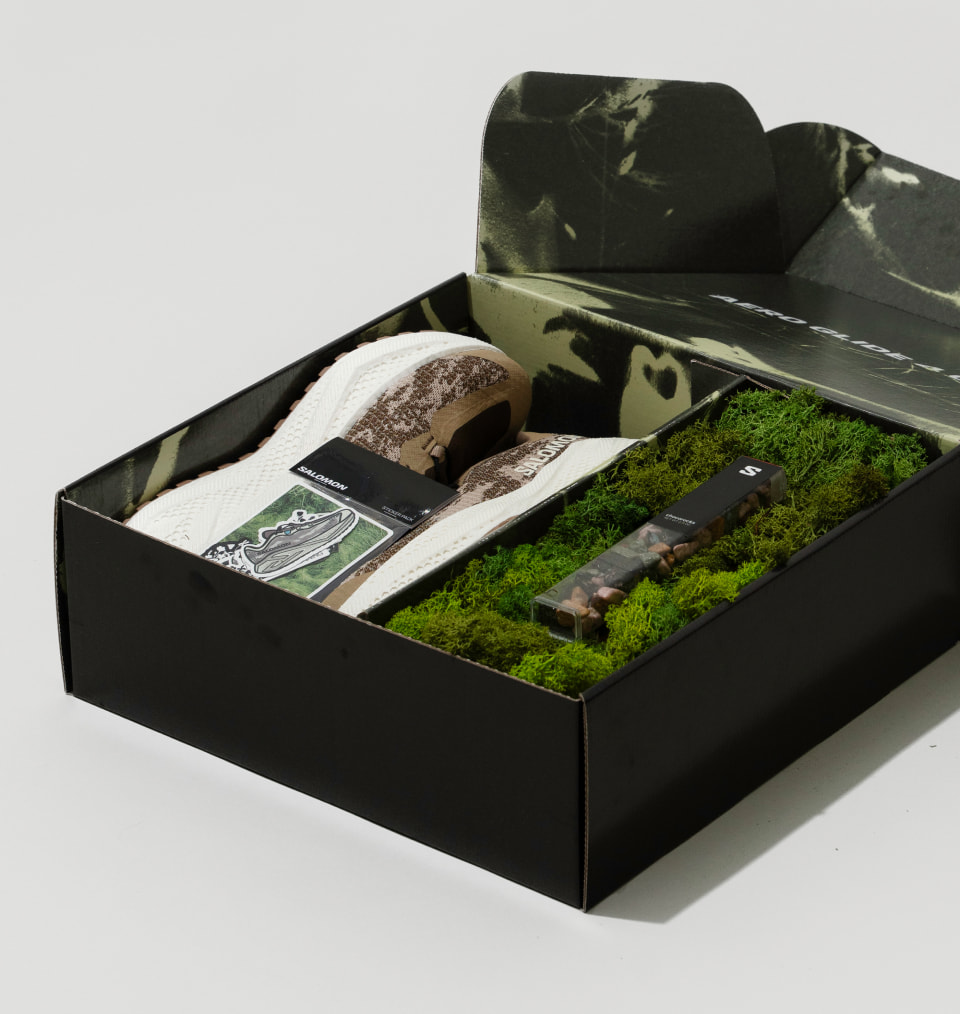 Open Salomon gift box featuring a custom trail shoe and branded accessories