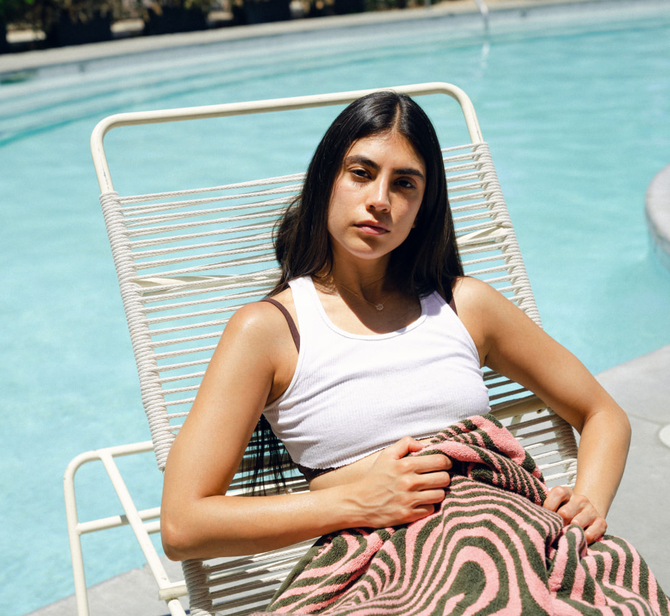 Model on pool lounger with custom towel