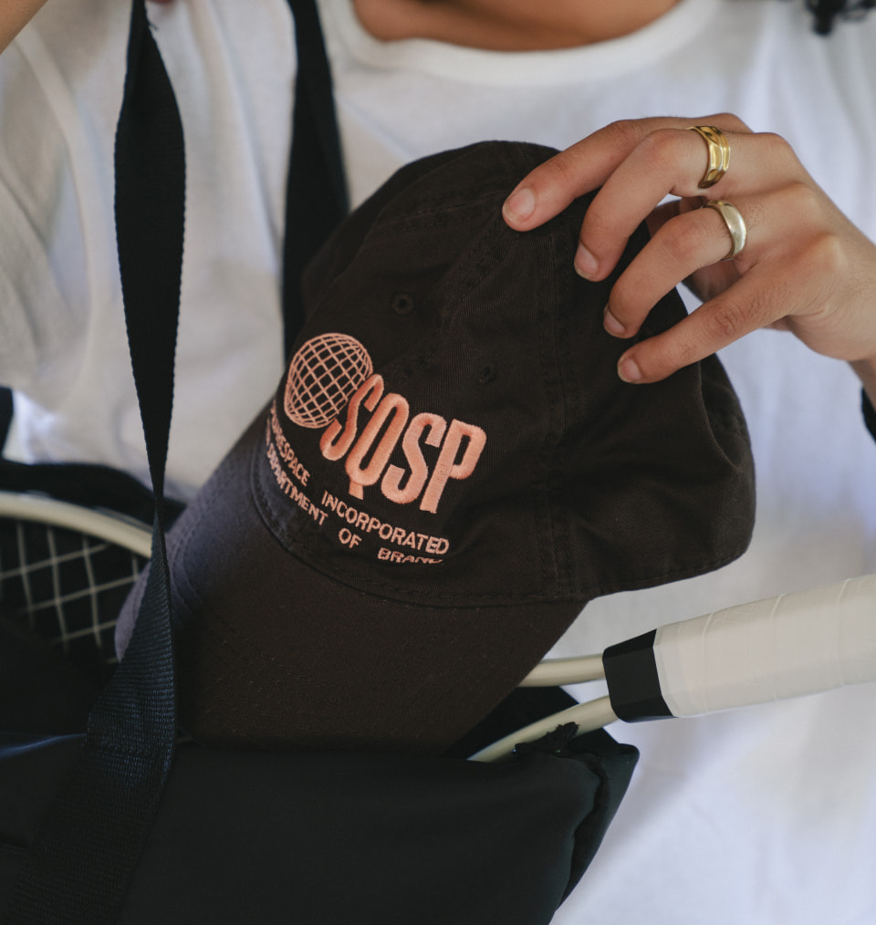 Closeup shot of model holding SquareSpace custom embroidered cap
