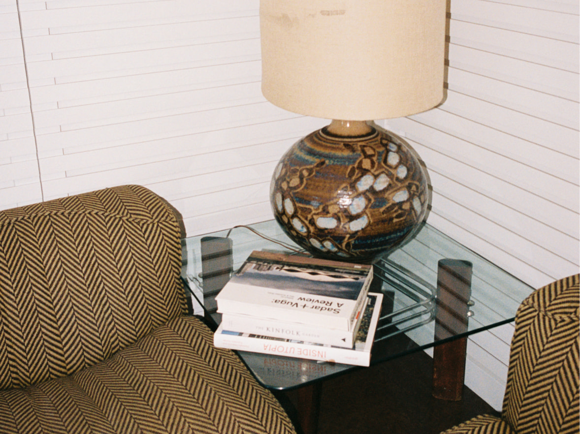 close up shot of living room featuring lamp and stack of books
