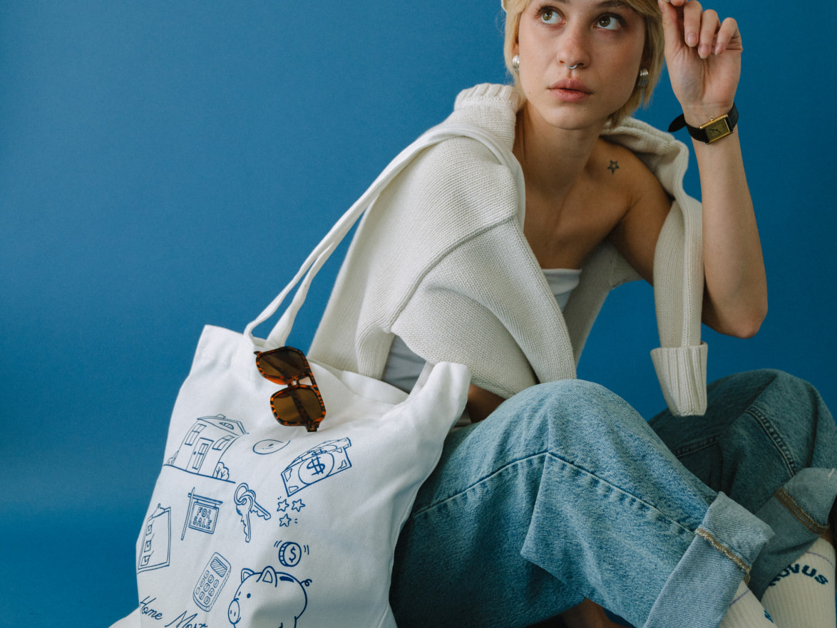 Model holding custom printed white tote bag wearing sunglasses