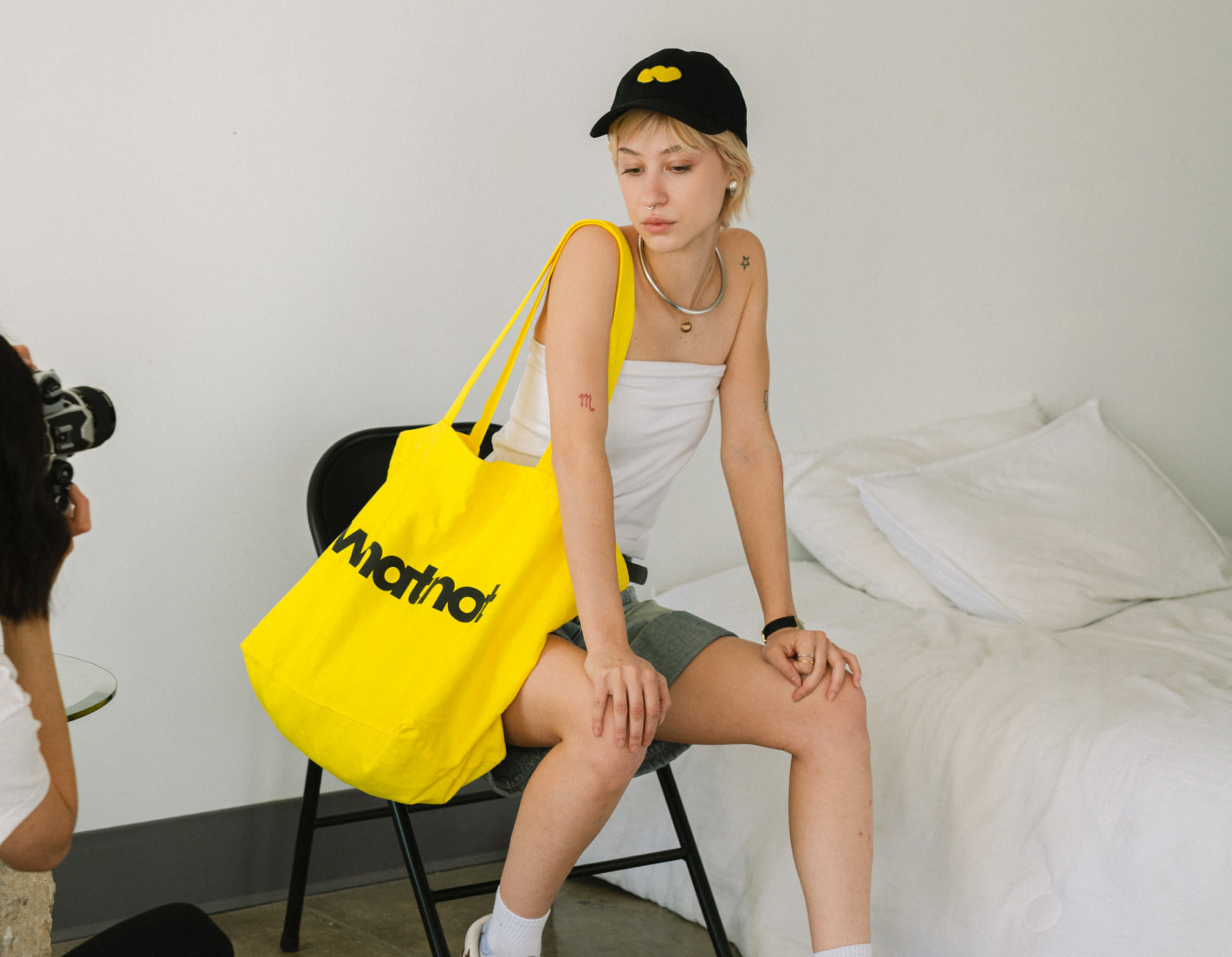 Whatnot custom yellow tote bag and black embroidered cap on model