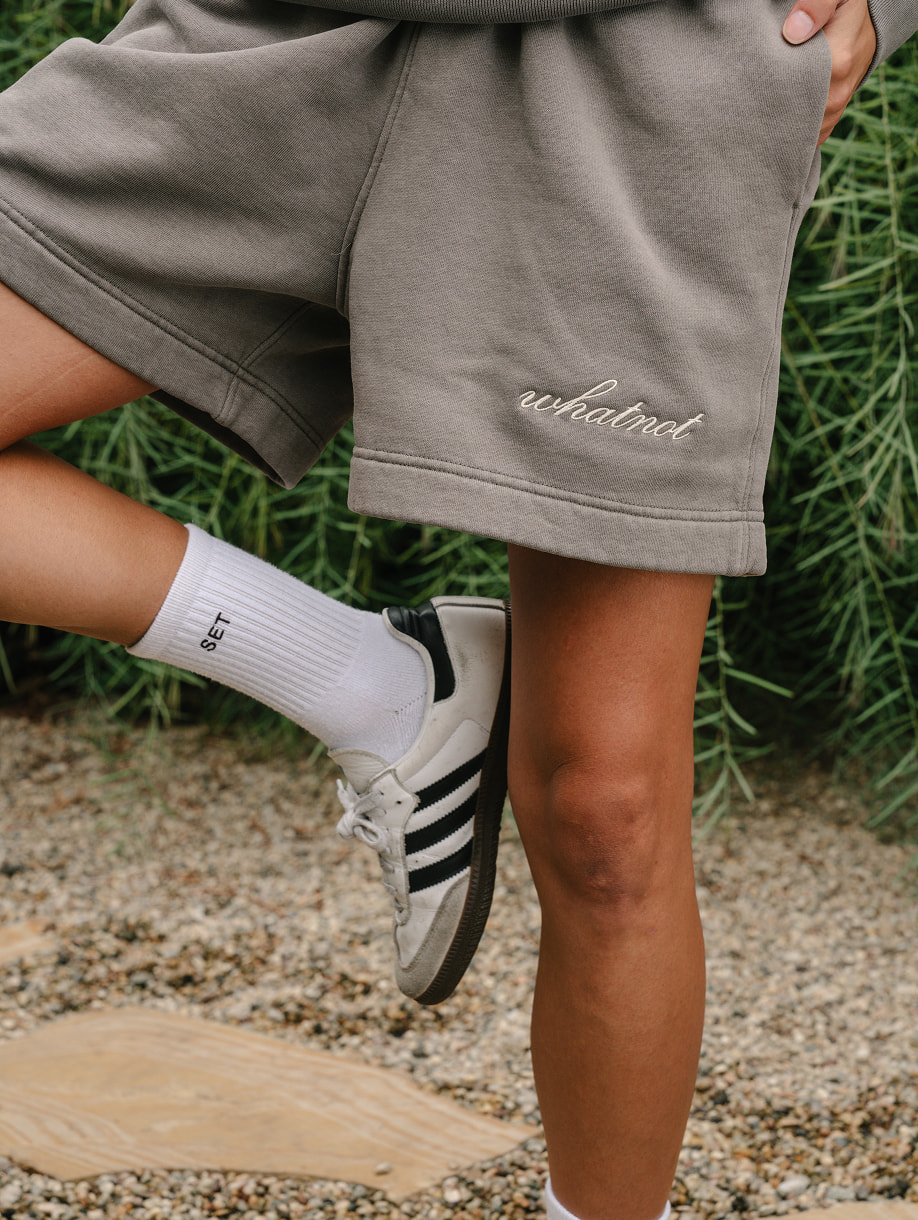 Whatnot custom gray shorts with embroidered white logo on model