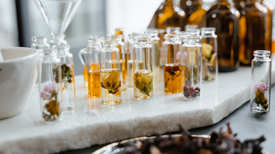 Flesjes met geurextracten en gedroogde bloemen in een parfumlabo