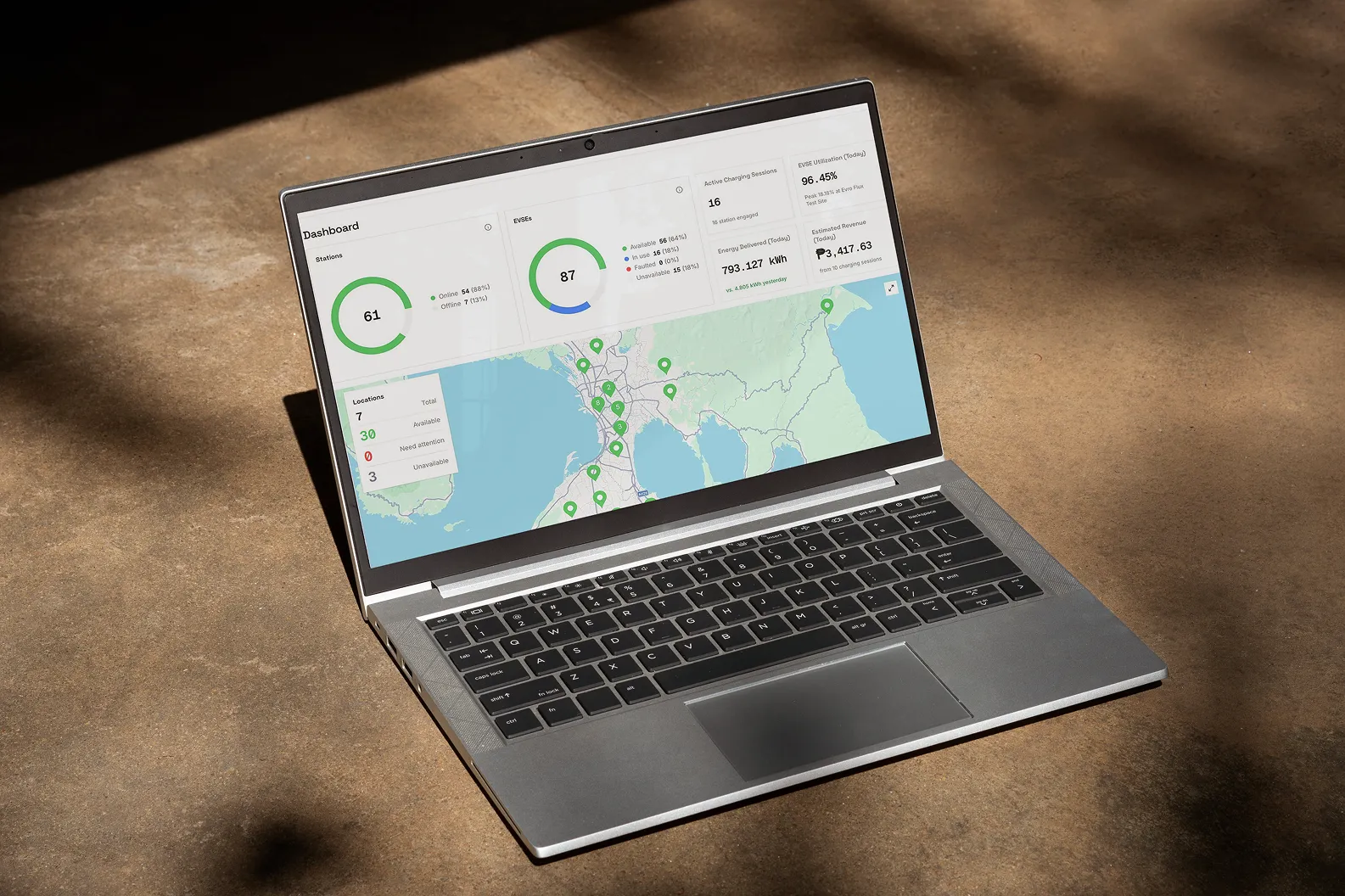 Laptop showing the Evro charging dashboard and station map.