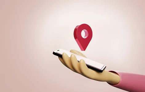 Hand holding a phone with a location pin above it.