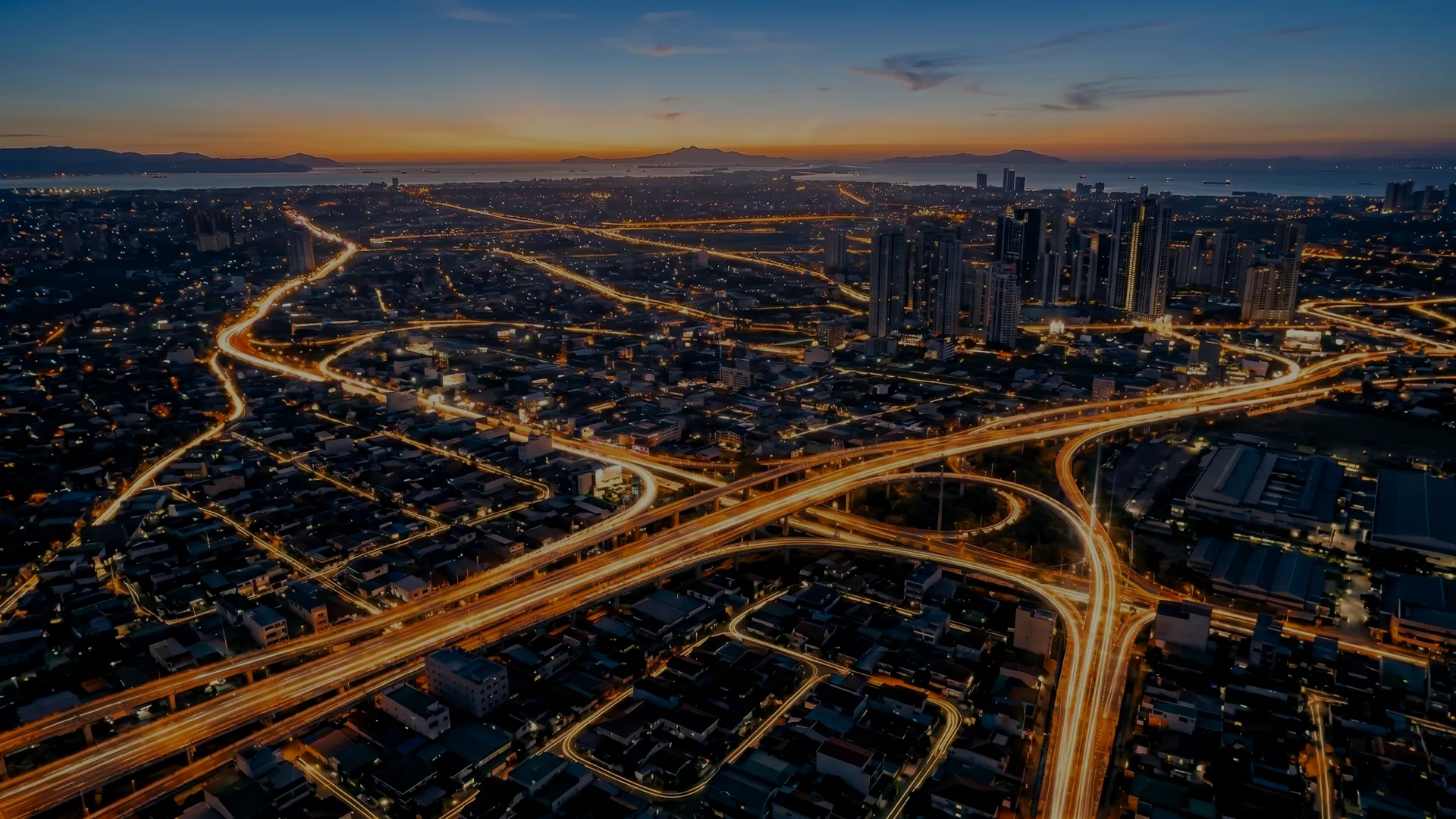 Aerial view of a city highway network at dusk.