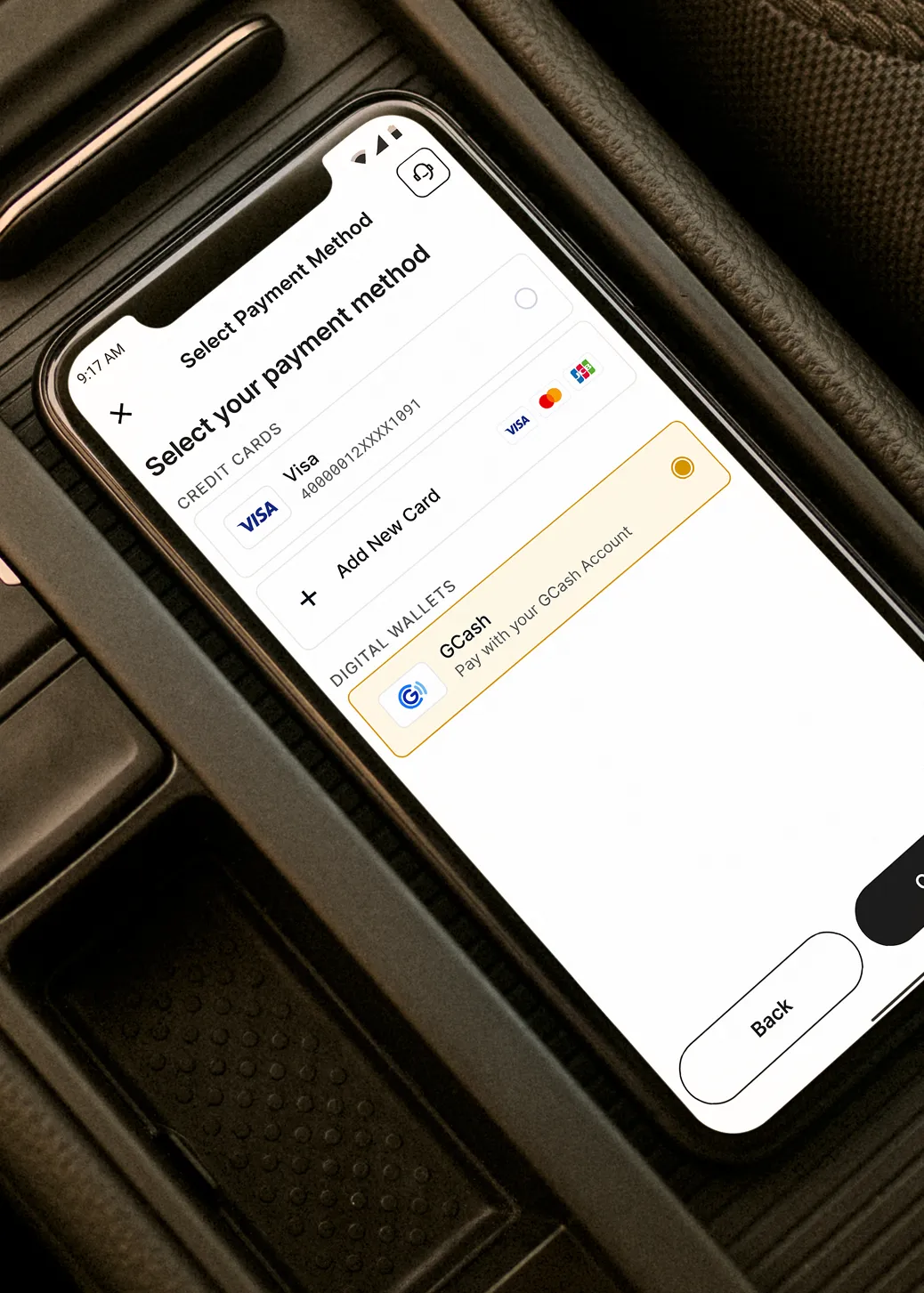 Phone in a car showing Evro payment options, including Visa and GCash.