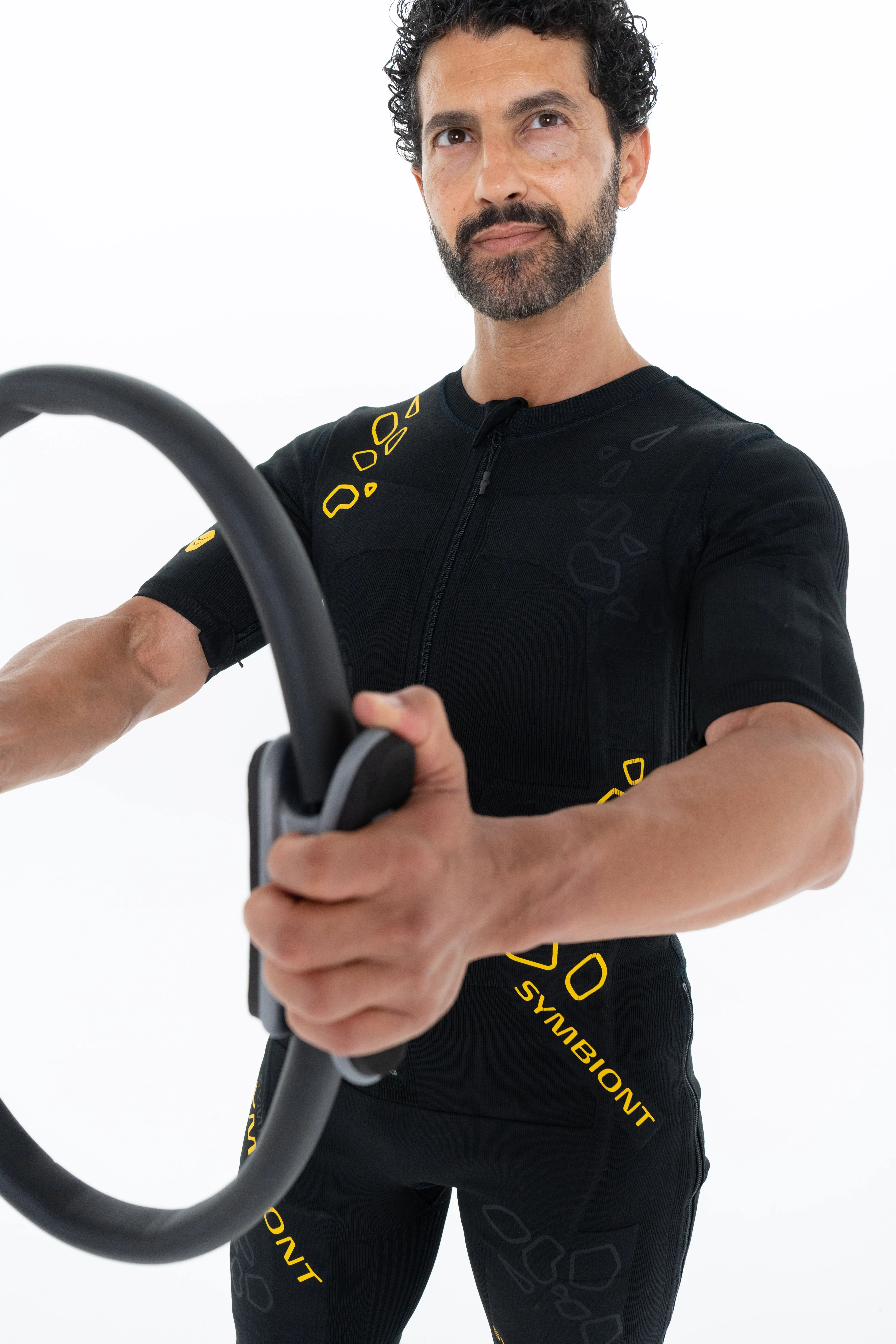 Homme réalisant un exercice avec anneau de Pilates en combinaison SYMBIONT