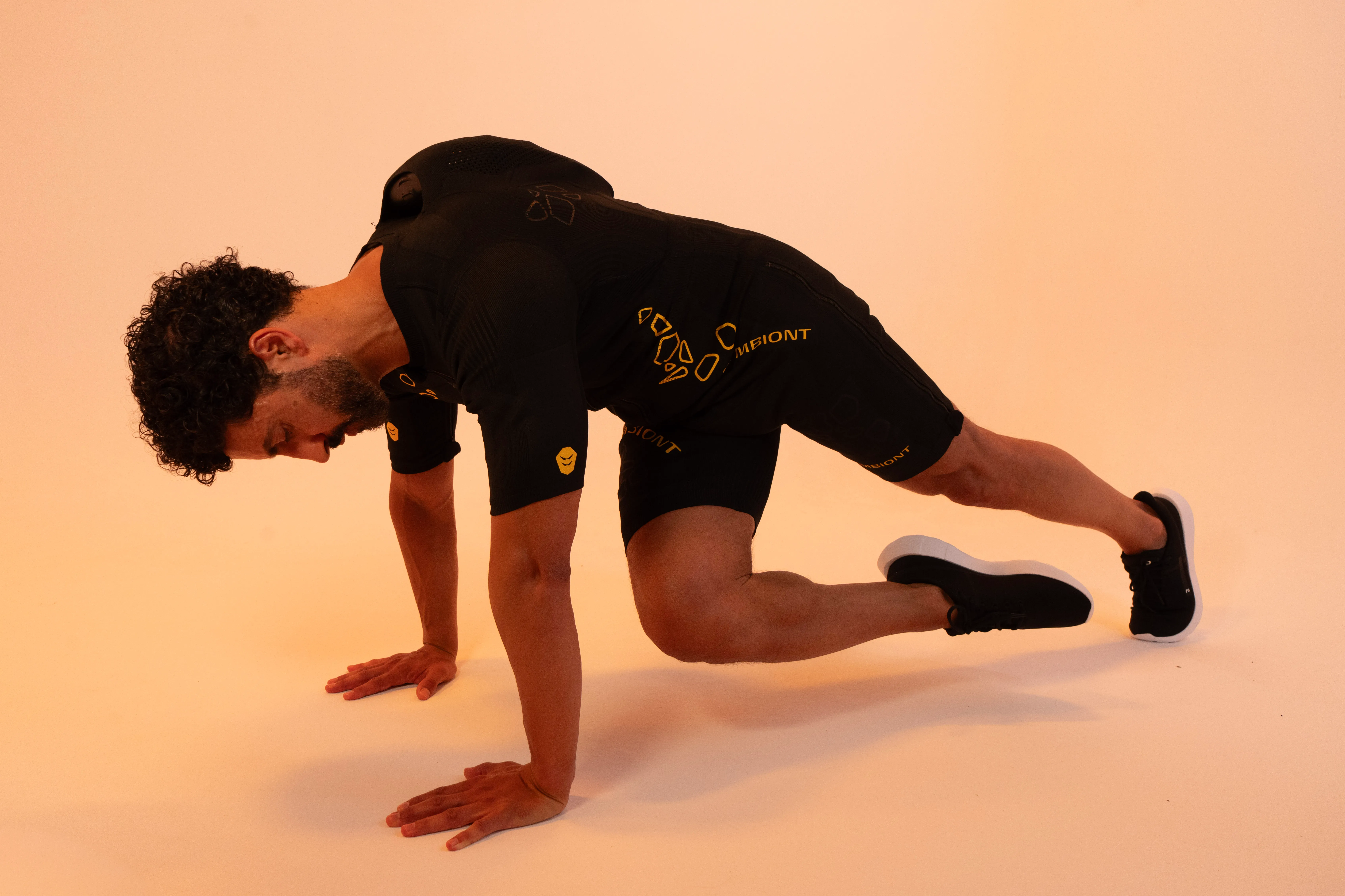 Homme réalisant des mountain climbers en combinaison d'électrostimulation SYMBIONT
