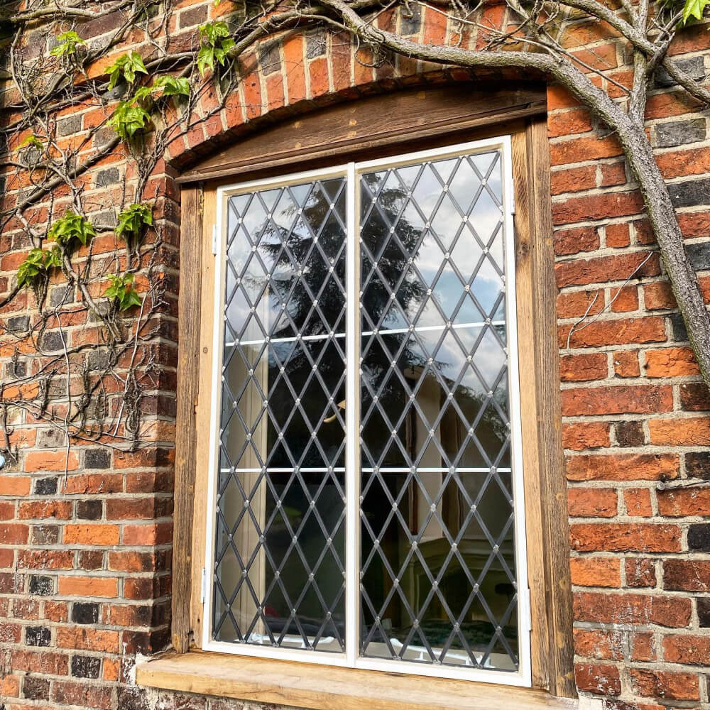 Close up of a wooden window frame on the side of a red brick house.