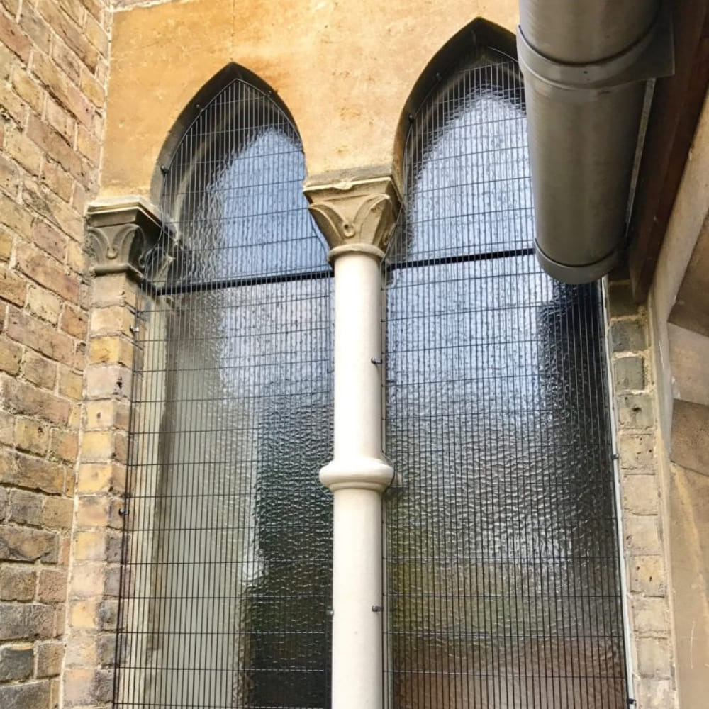 Close up of a wooden window frame on the side of a red brick house.